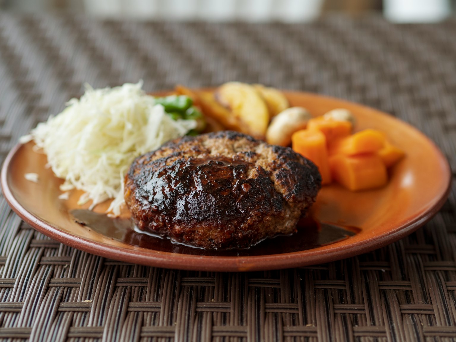 Ein Teller mit Hamburgersteak, Reis und verschiedenen Gemüsebeilagen