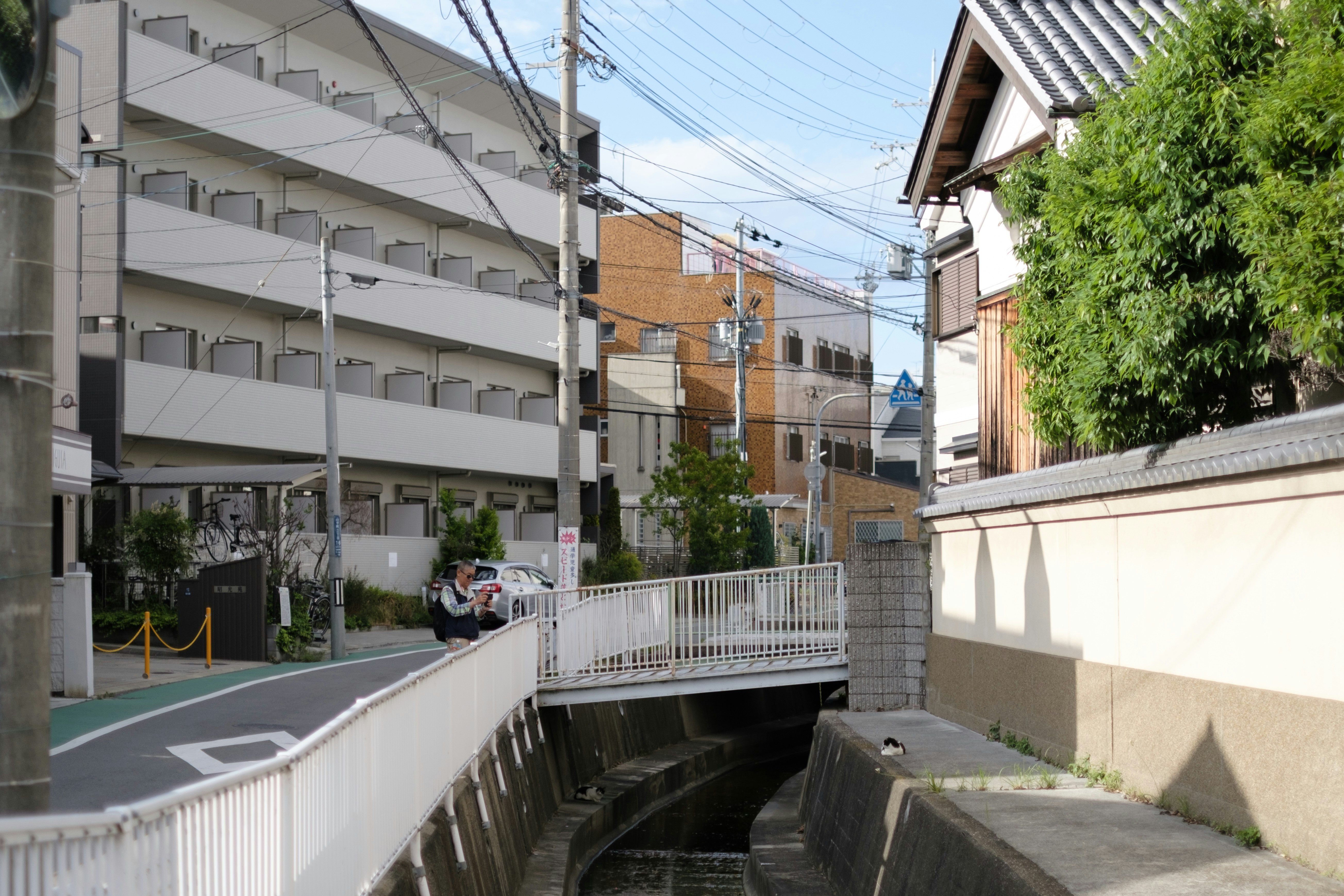 路地の坂道にある住宅とフェンスのある通路