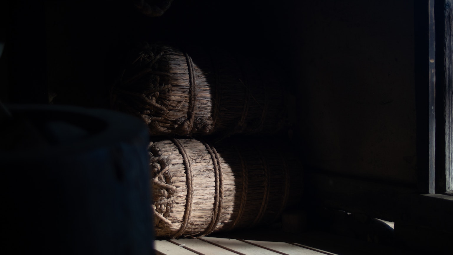 Fûts en bois empilés dans un fond sombre