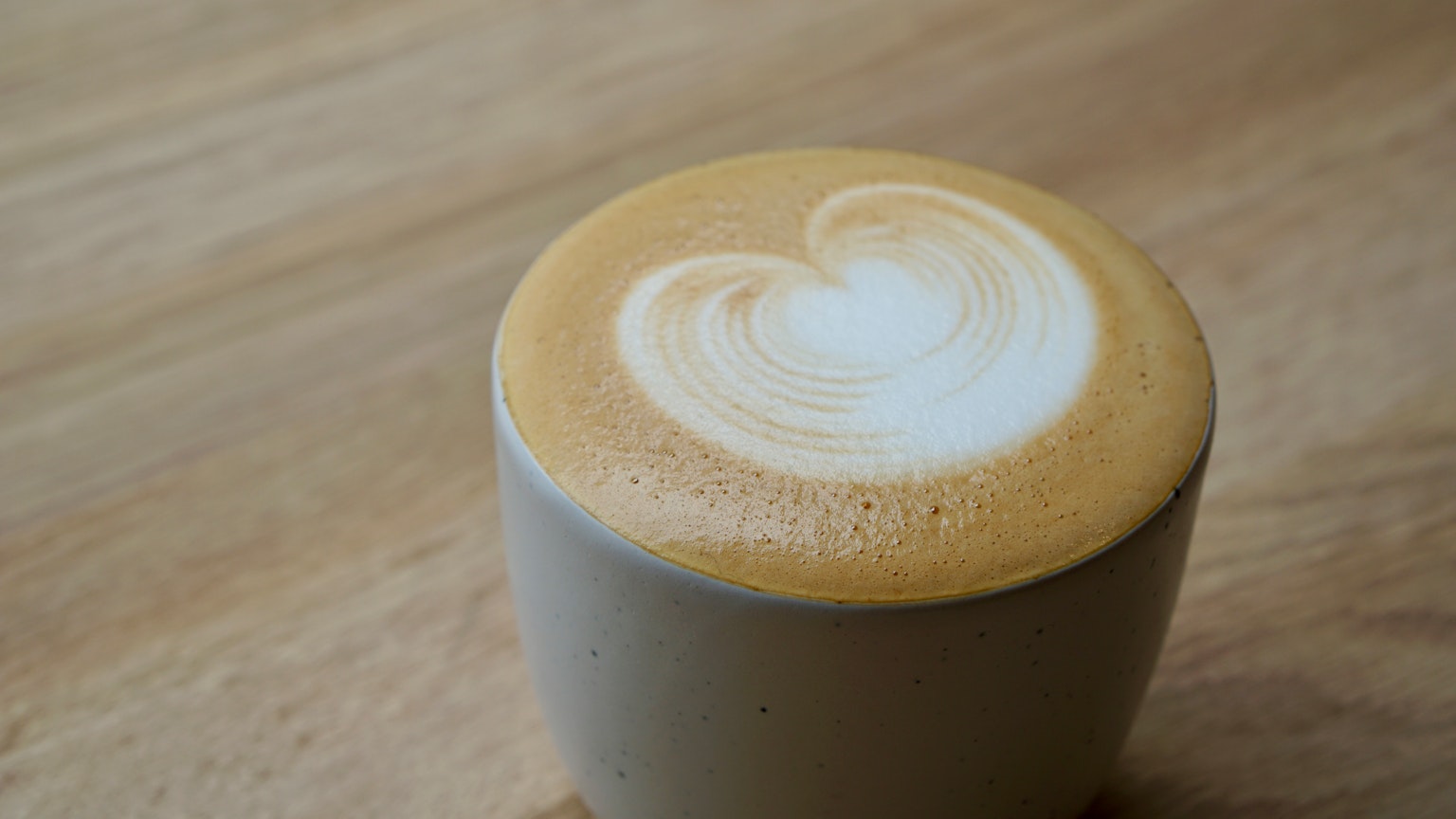 A cup of coffee with creamy latte art resembling a heart