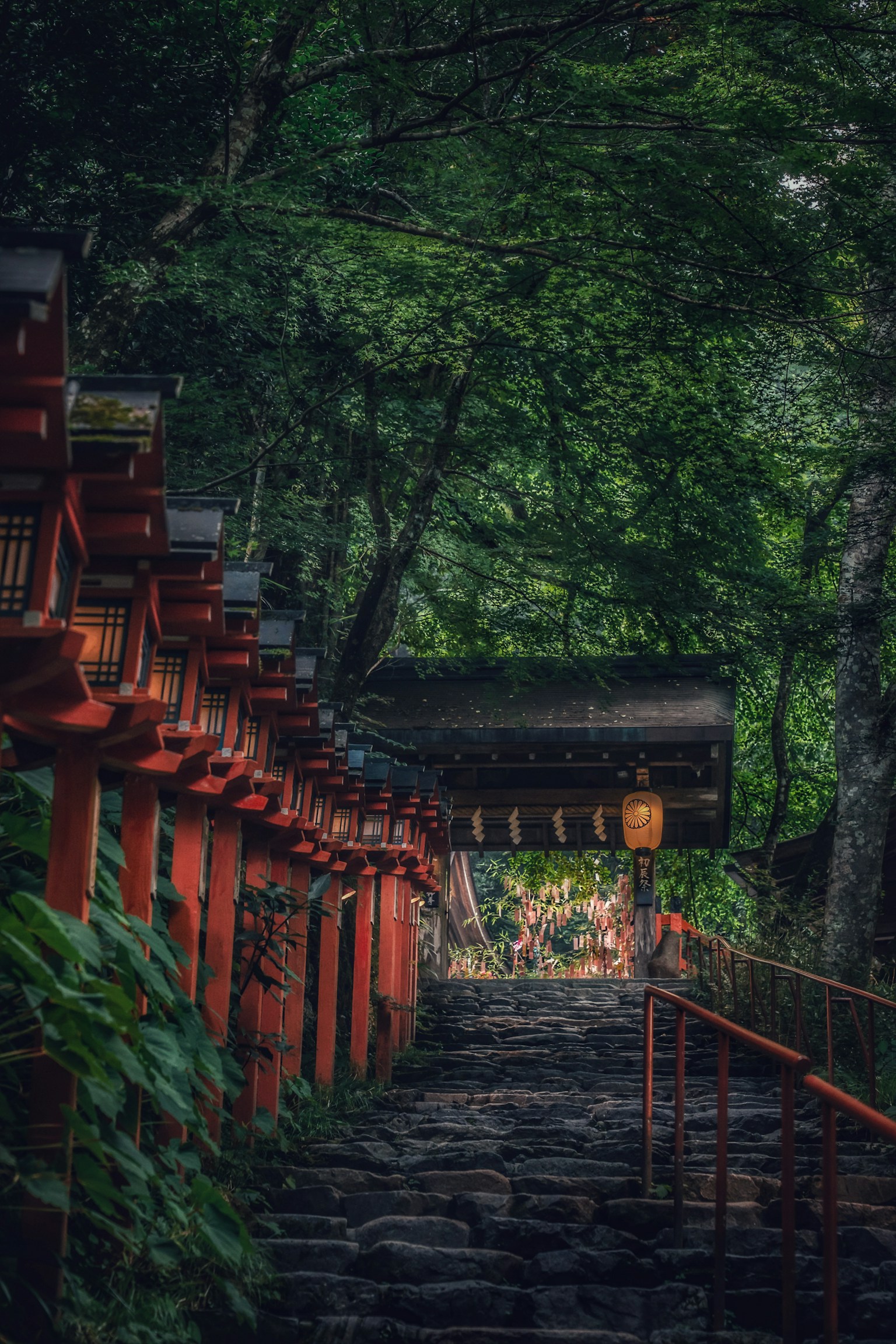 Tangga batu yang mengarah melalui hutan dengan gerbang torii merah