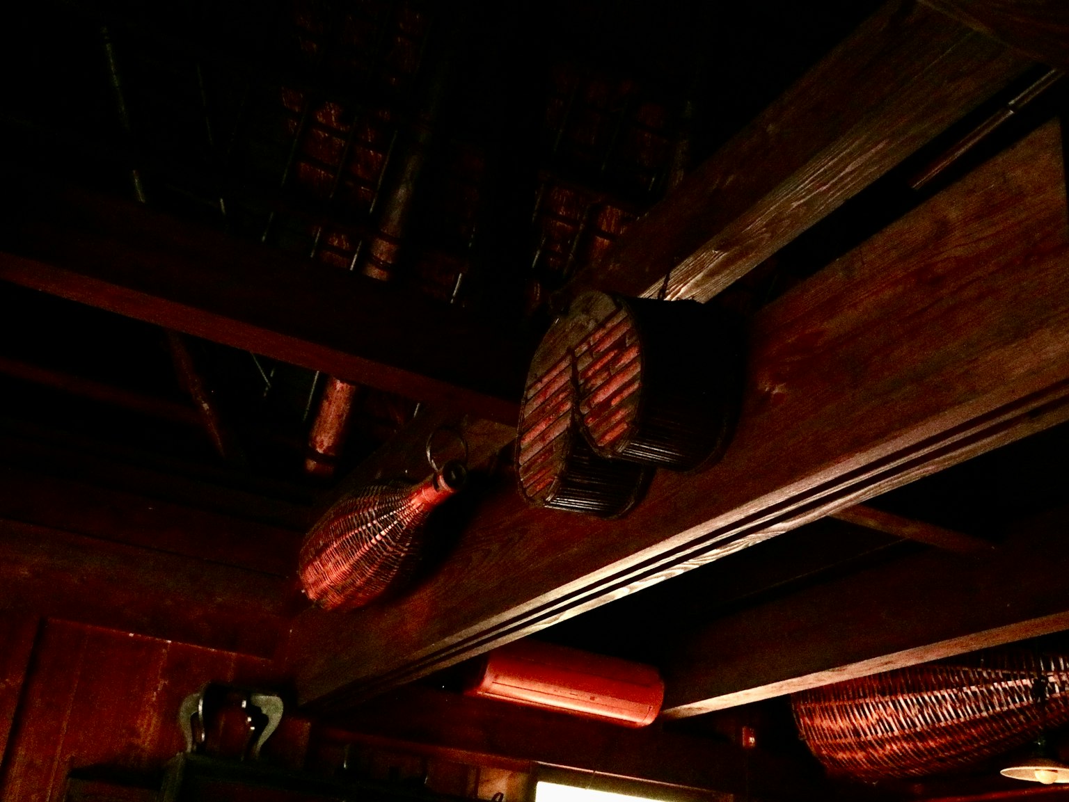 Outils et décorations traditionnels suspendus à des poutres en bois