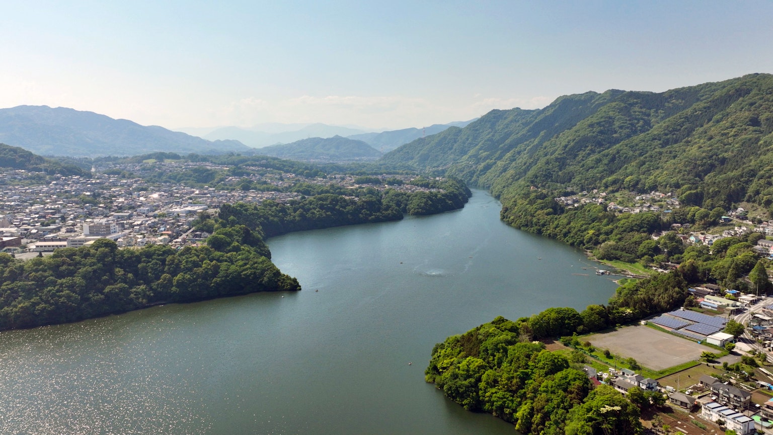 Panoramablick auf einen Fluss zwischen grünen Bergen