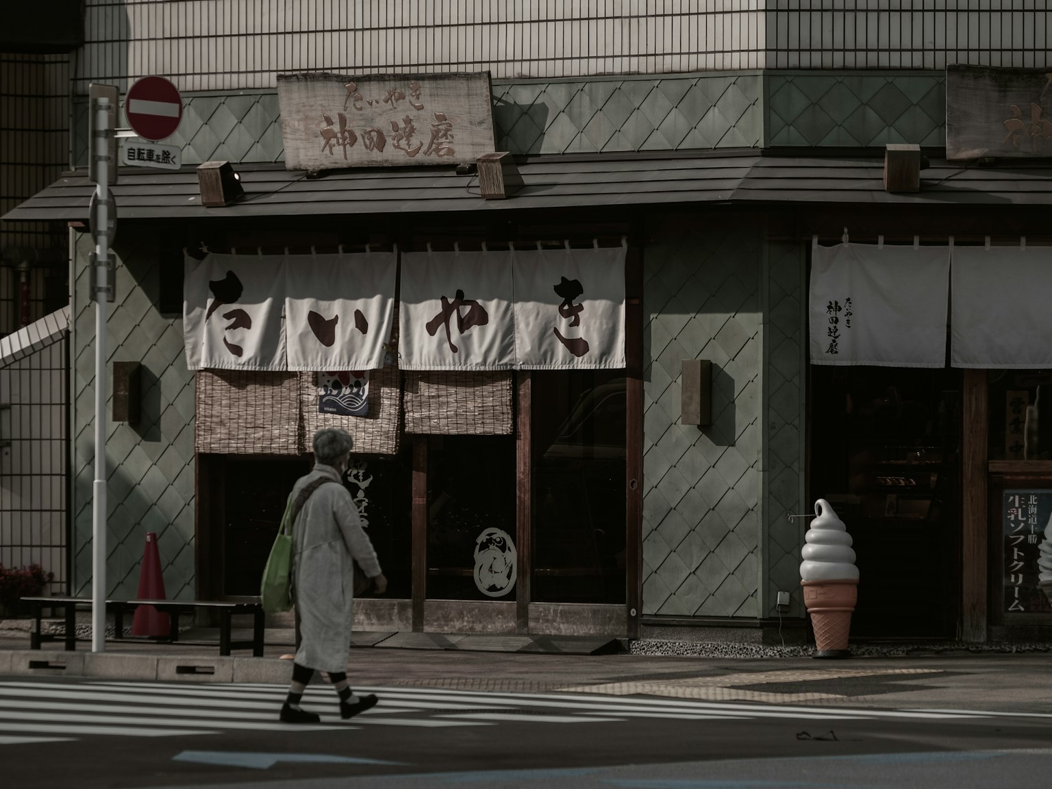 Một góc phố yên tĩnh với cửa hàng Nhật Bản truyền thống và một người đi bộ