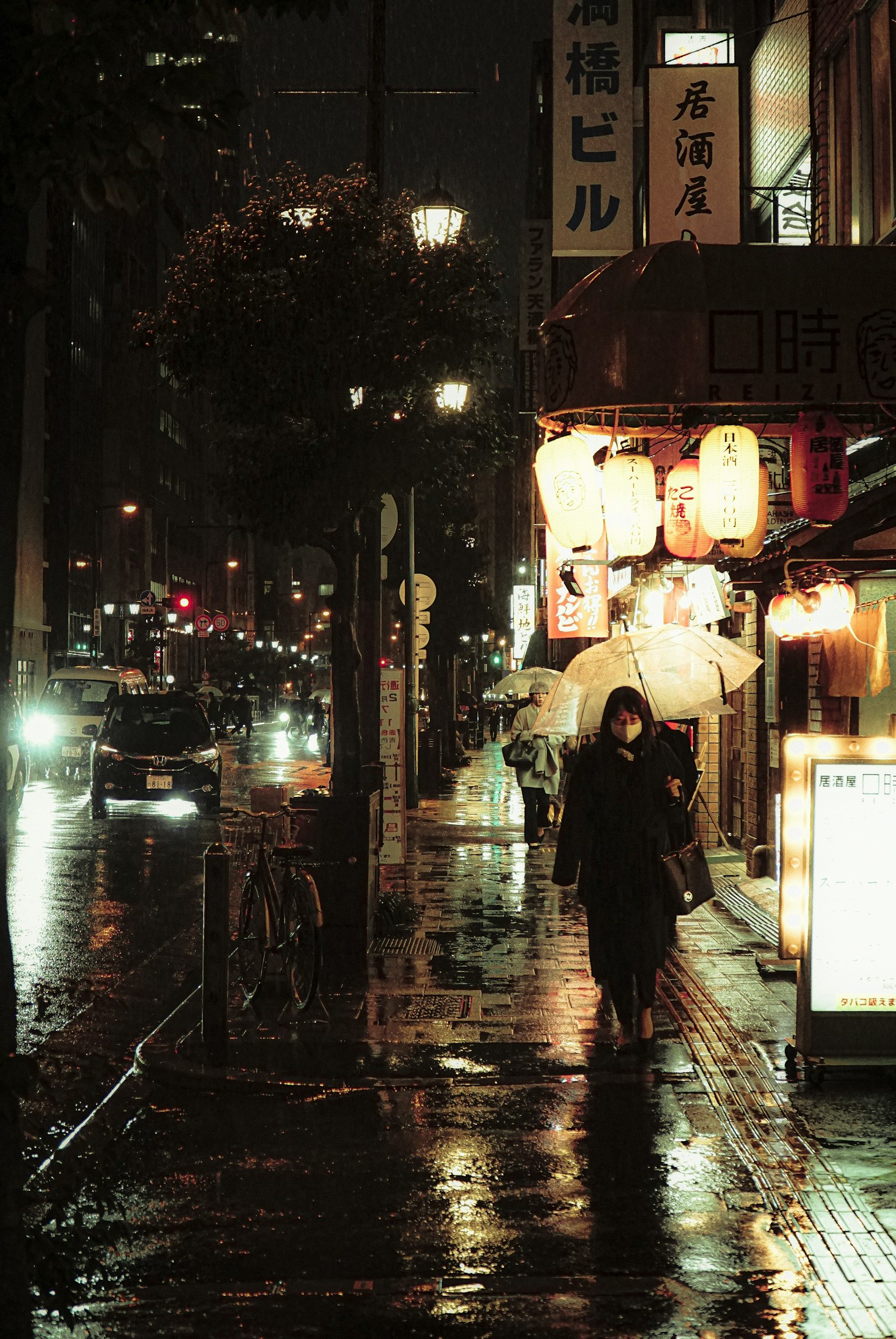 一個人在雨夜城市風景中拿著傘走