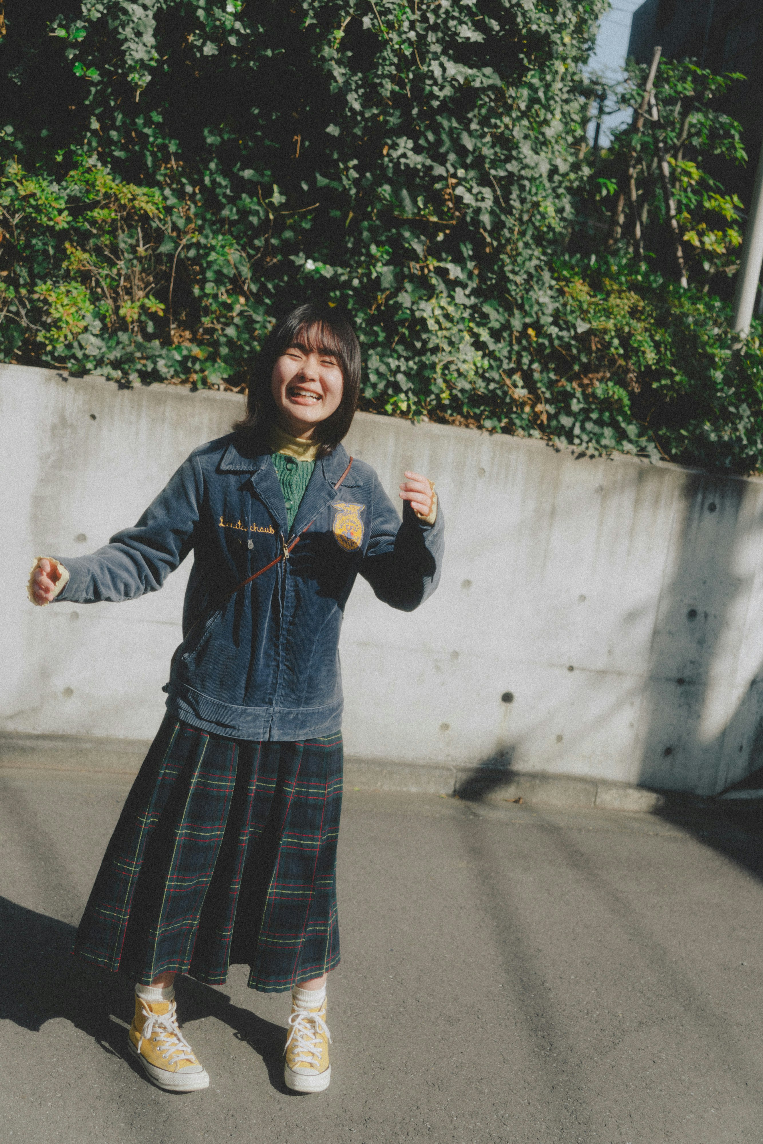 壁沿いの木々に囲まれた笑顔の子ども
