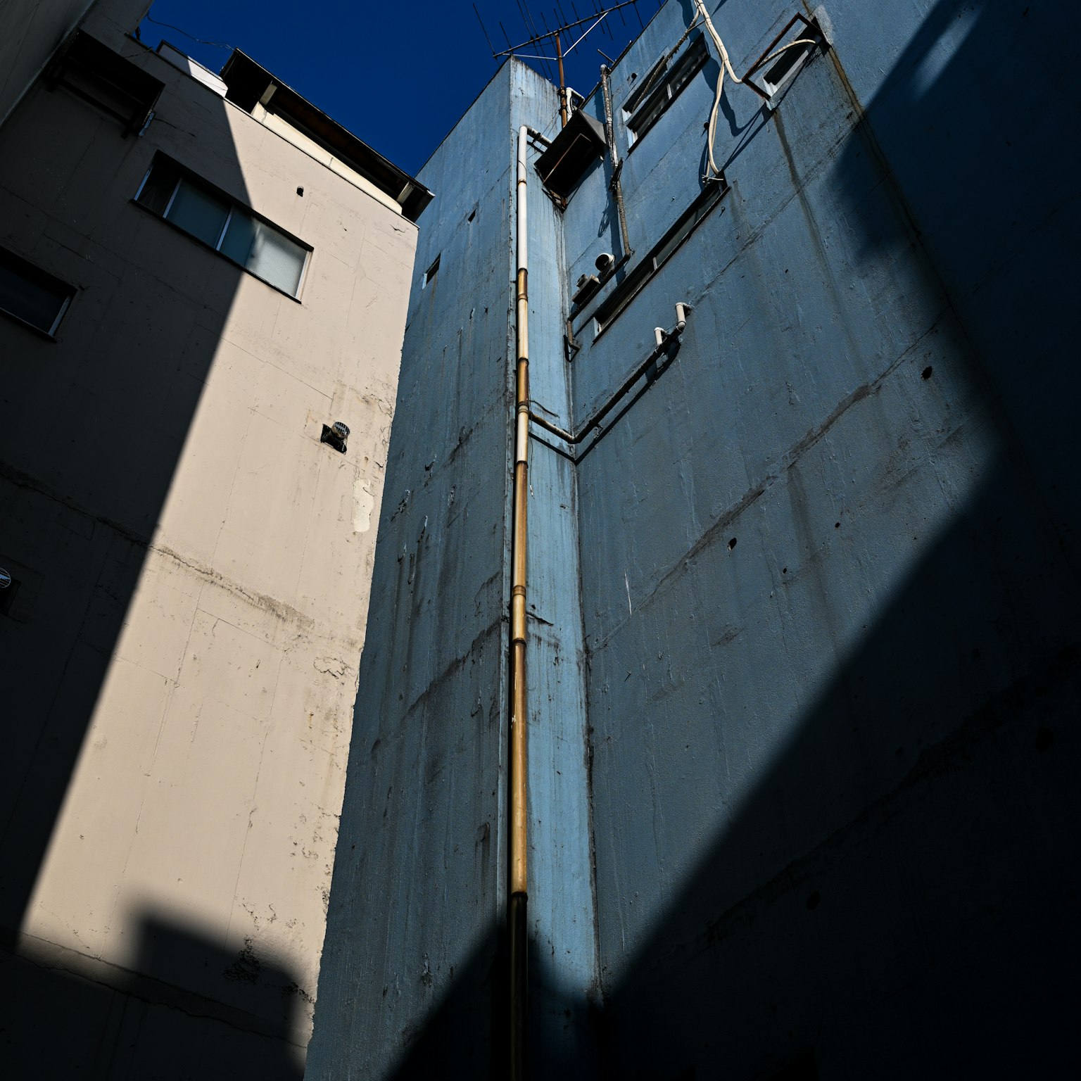Foto gang sempit dengan dinding biru dan bayangan