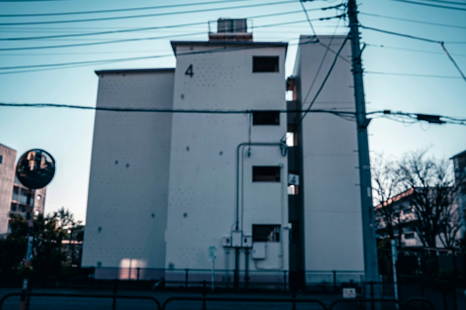 Four-story building with white exterior and visible power lines