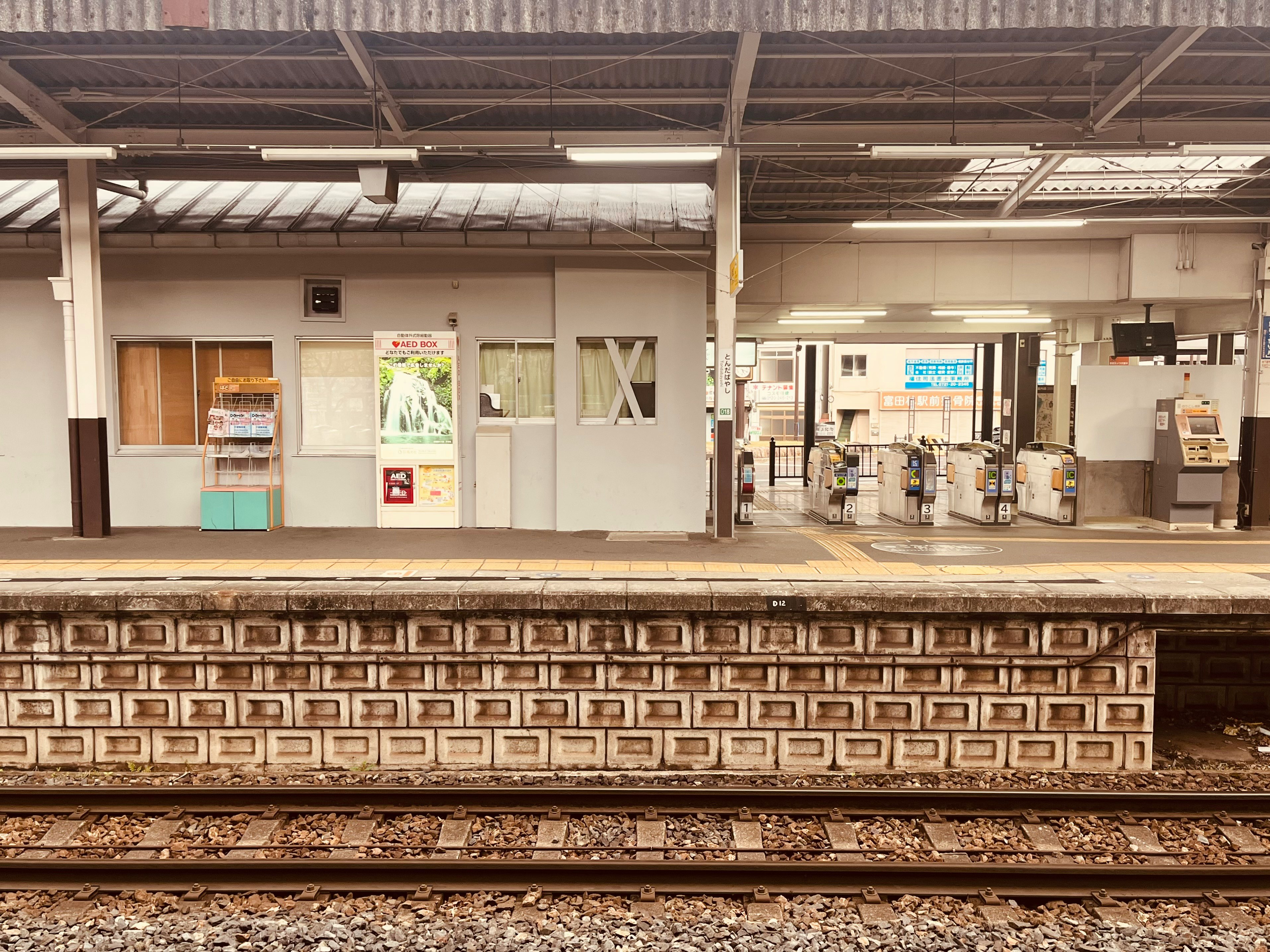 Wartebereich am Bahnsteig mit Drehkreuzen und Ticketautomaten