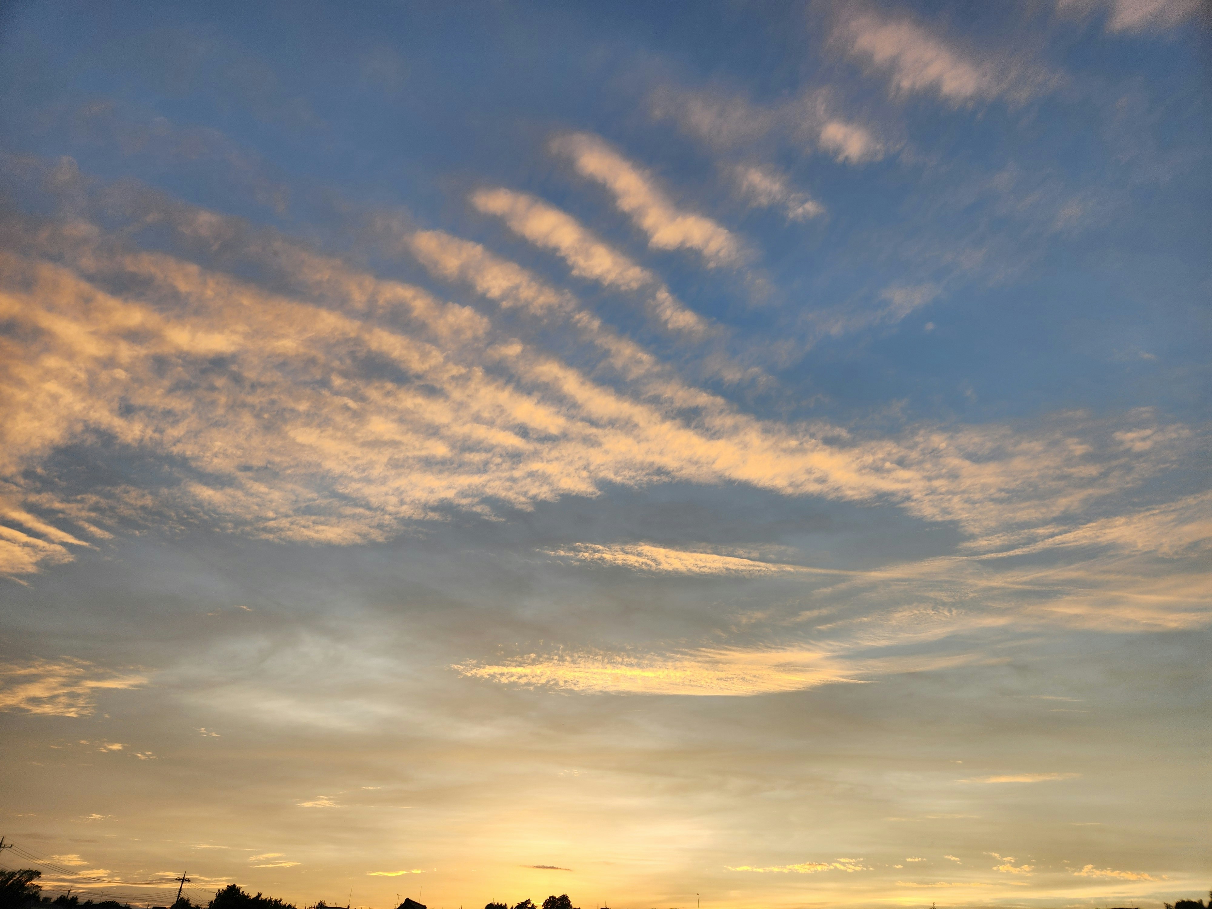 夕焼けの空に広がる雲の流れ