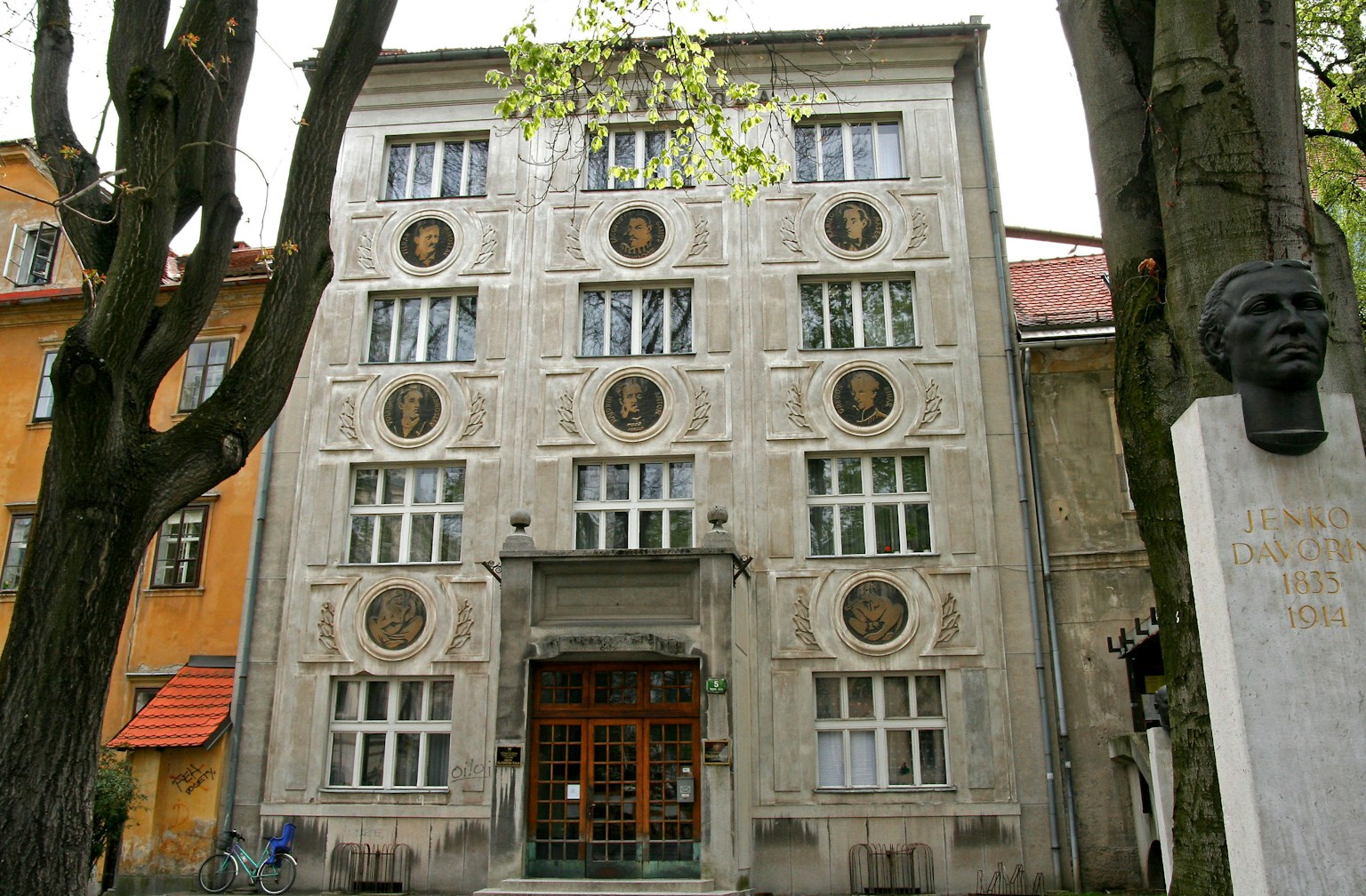 Facade of a building with unique decorative elements surrounded by trees