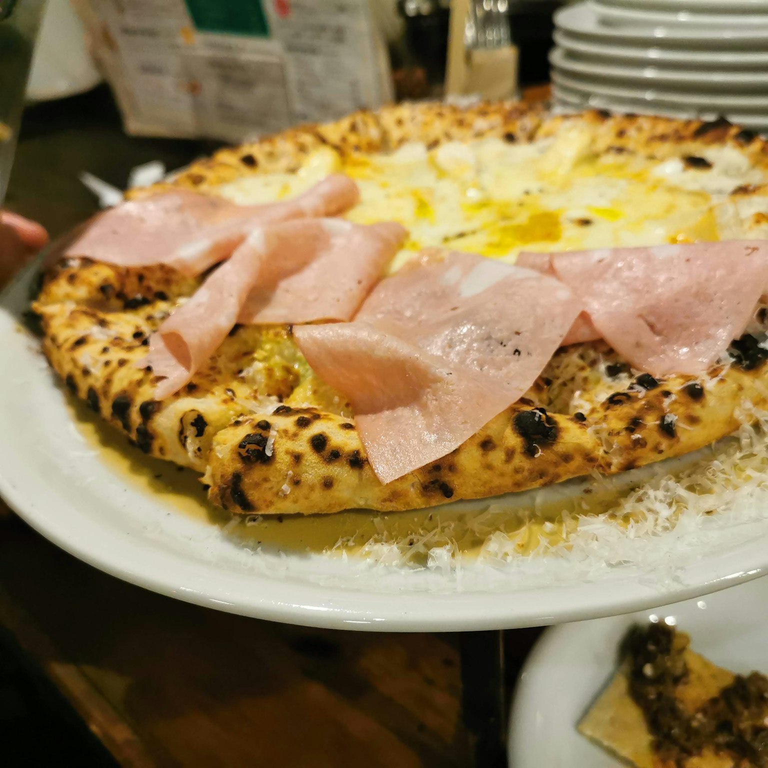 Pizza dengan ham di atas piring putih