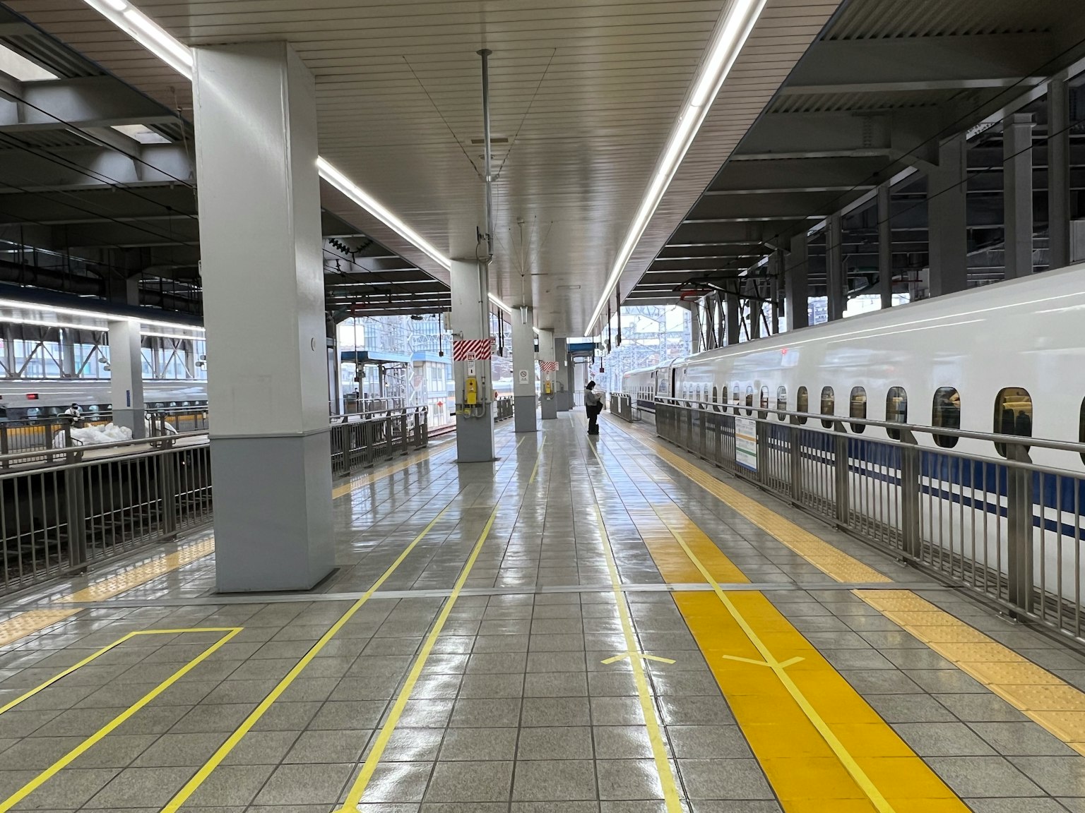 Intérieur d'une plateforme de gare Shinkansen avec une personne marchant
