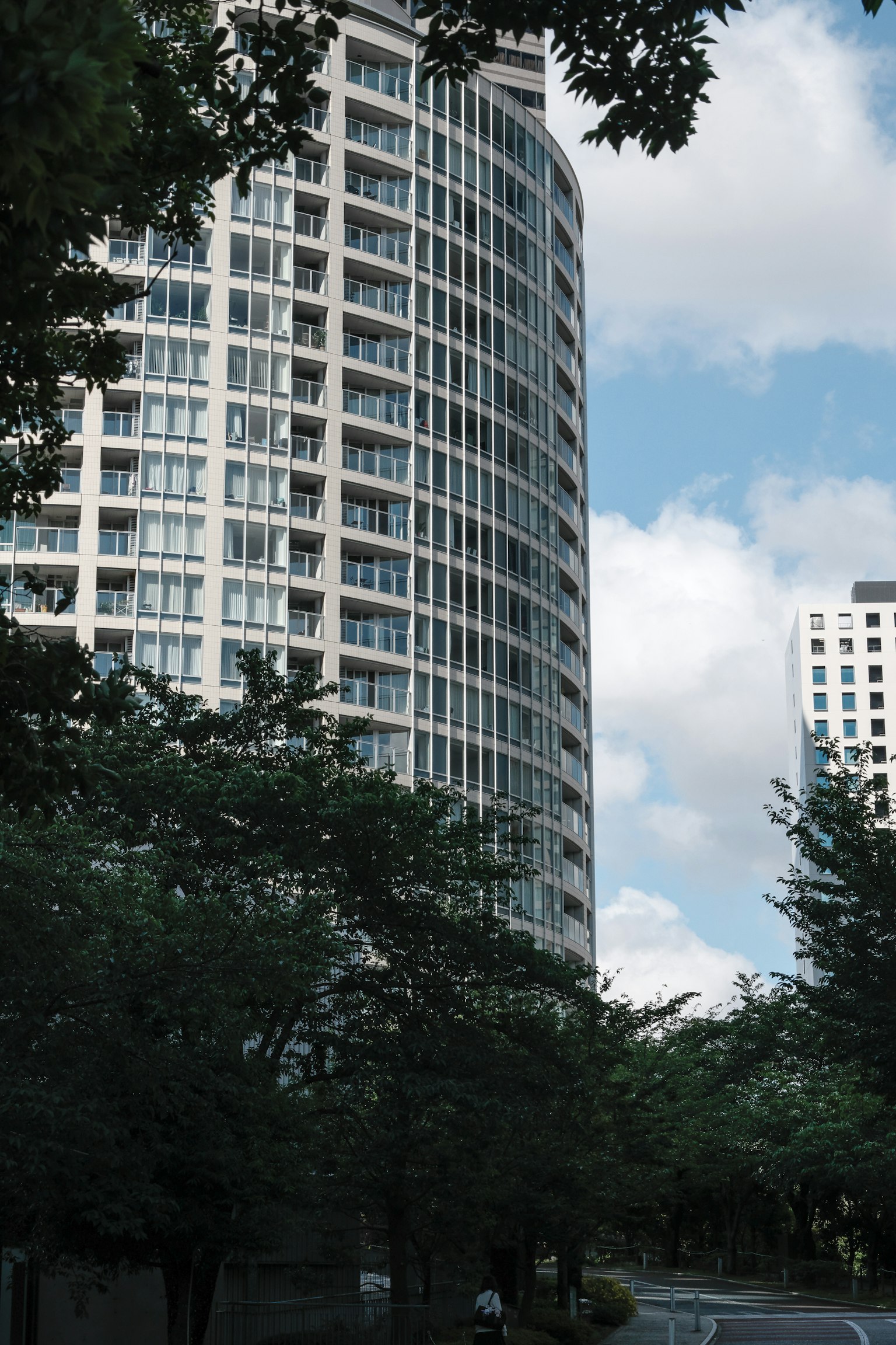 Modern high-rise building surrounded by greenery and blue sky