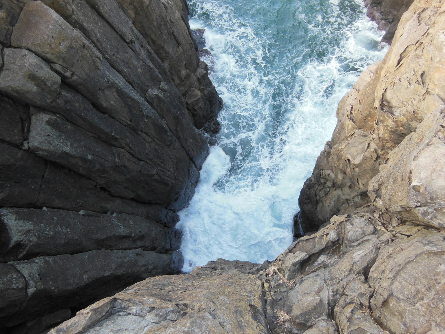 岩石懸崖之間海浪拍打的景象