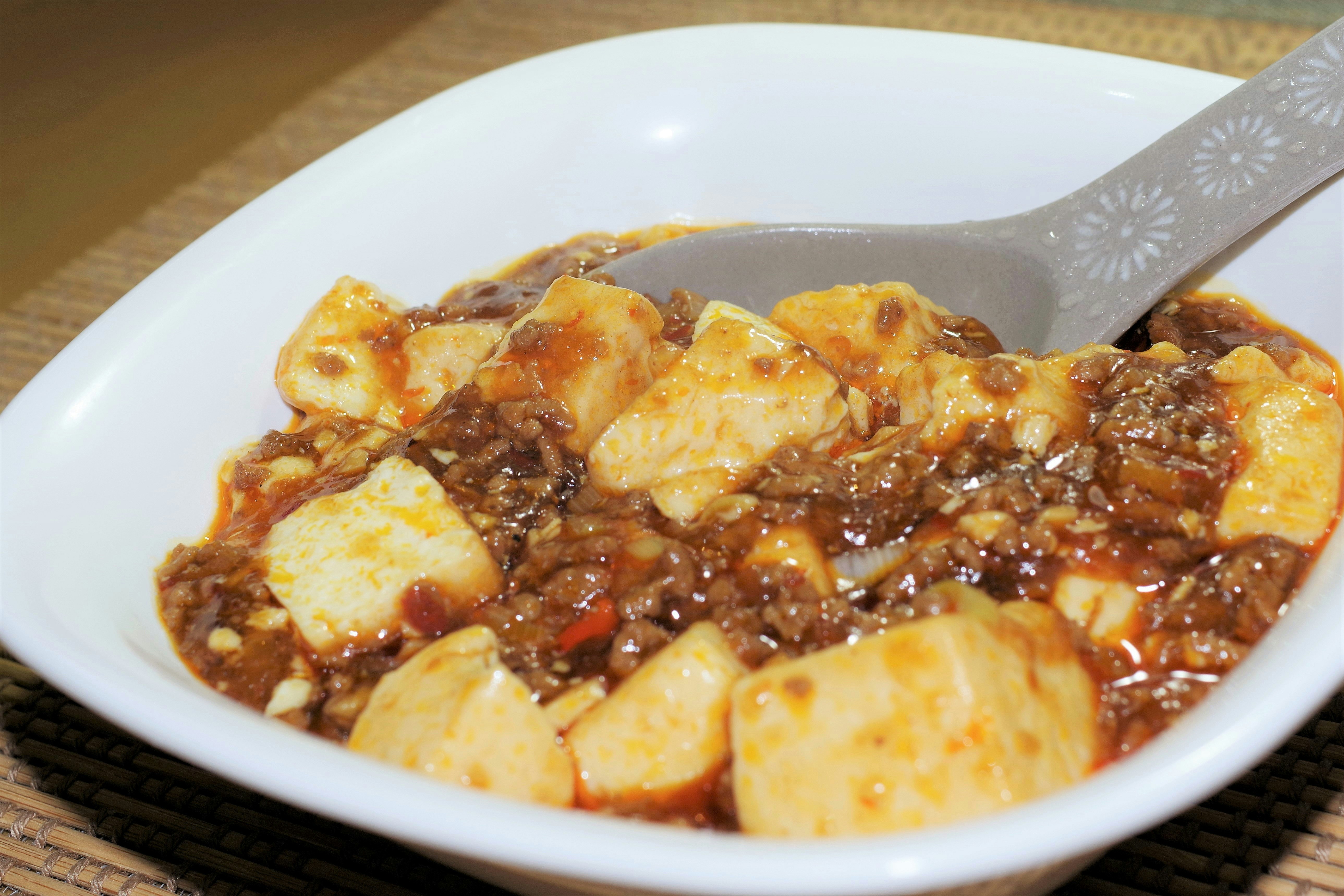 スプーンですくった麻婆豆腐風の煮込み