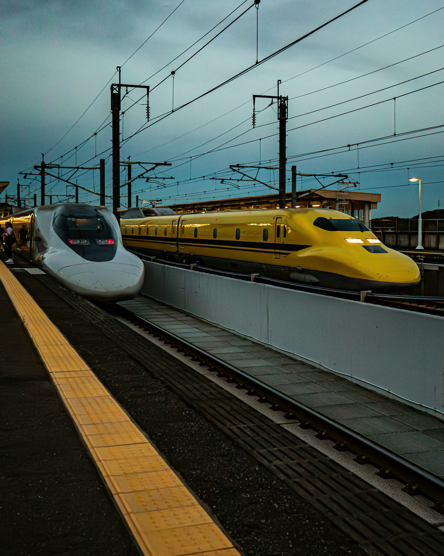 Shinkansen white train and yellow train at a station