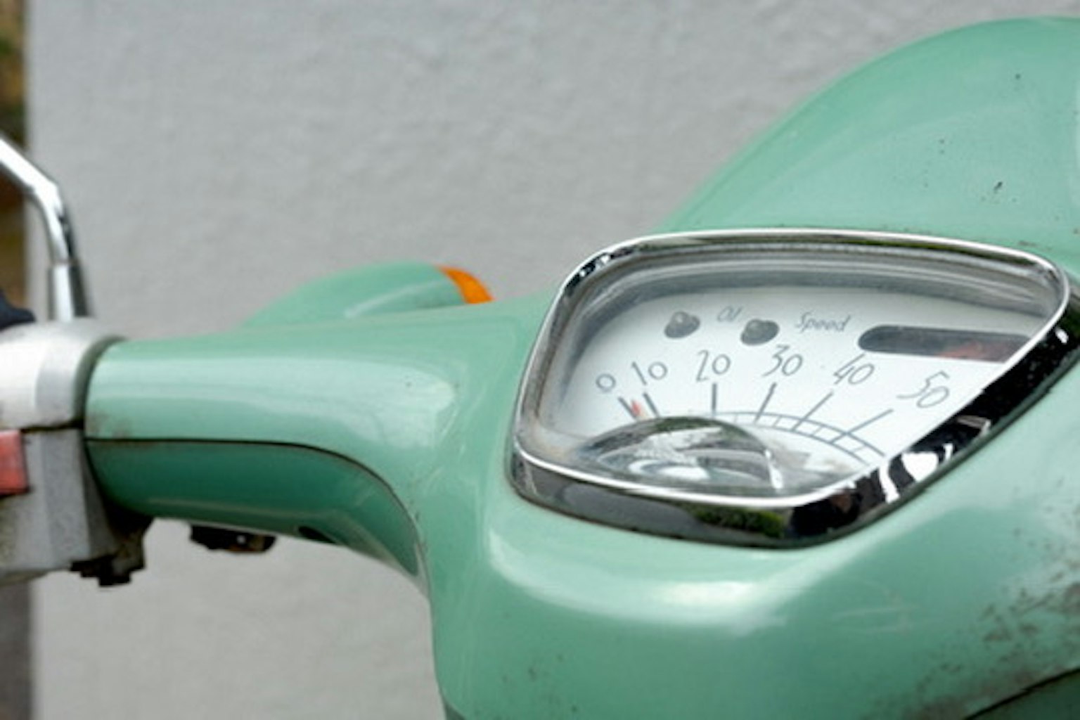 Gros plan sur le compteur d'une moto verte montrant le compteur de vitesse et les caractéristiques de design