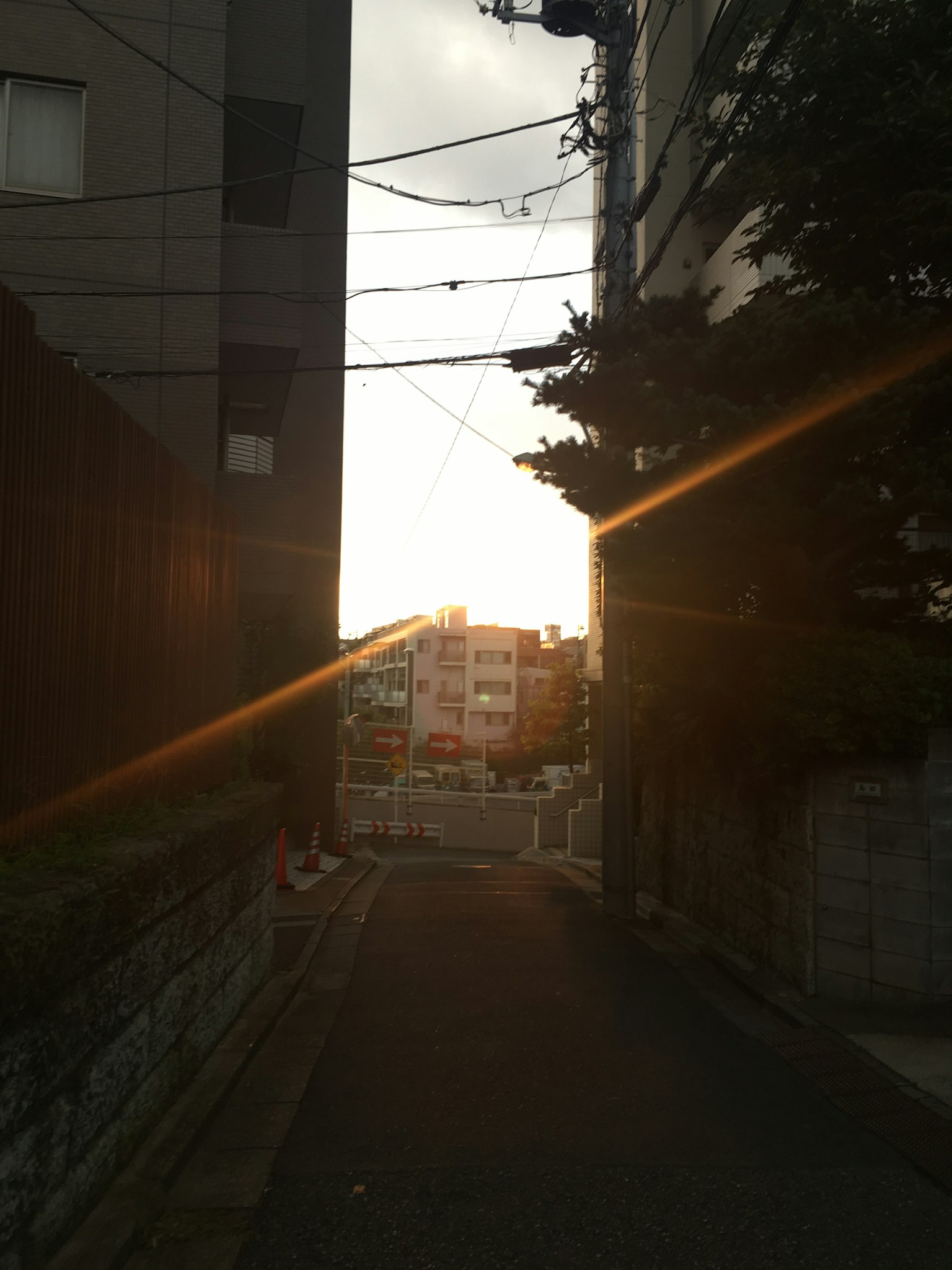 Enge Straße mit Sonnenlicht, das beim Sonnenuntergang durchscheint