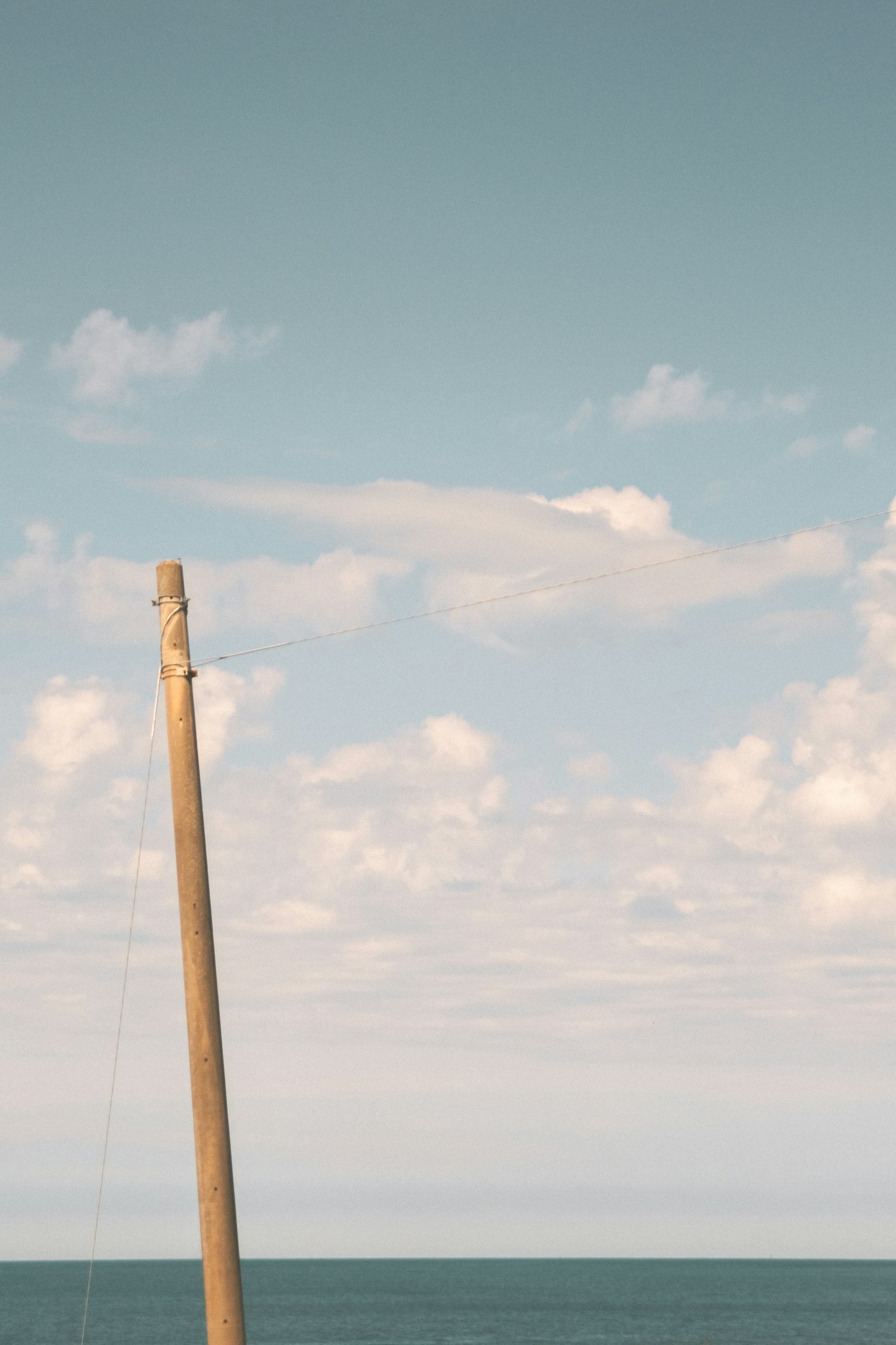 Palo di legno contro uno sfondo di mare e cielo blu