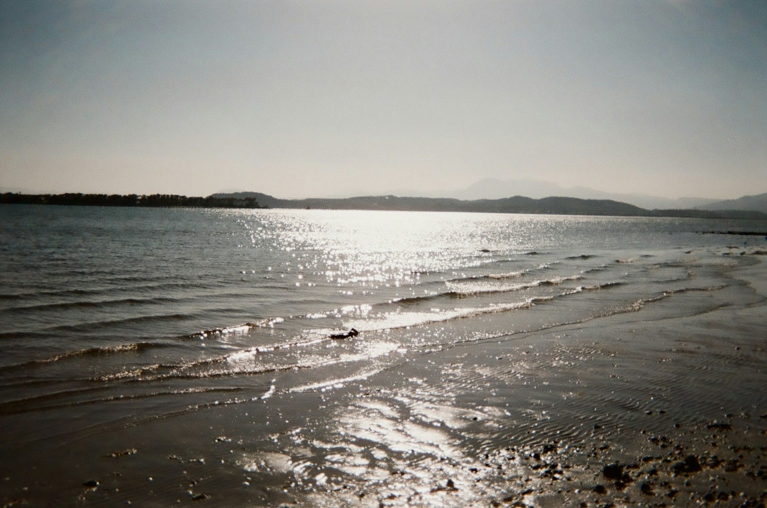 Vue paisible sur la mer avec la lumière du soleil se reflétant sur le rivage sablonneux