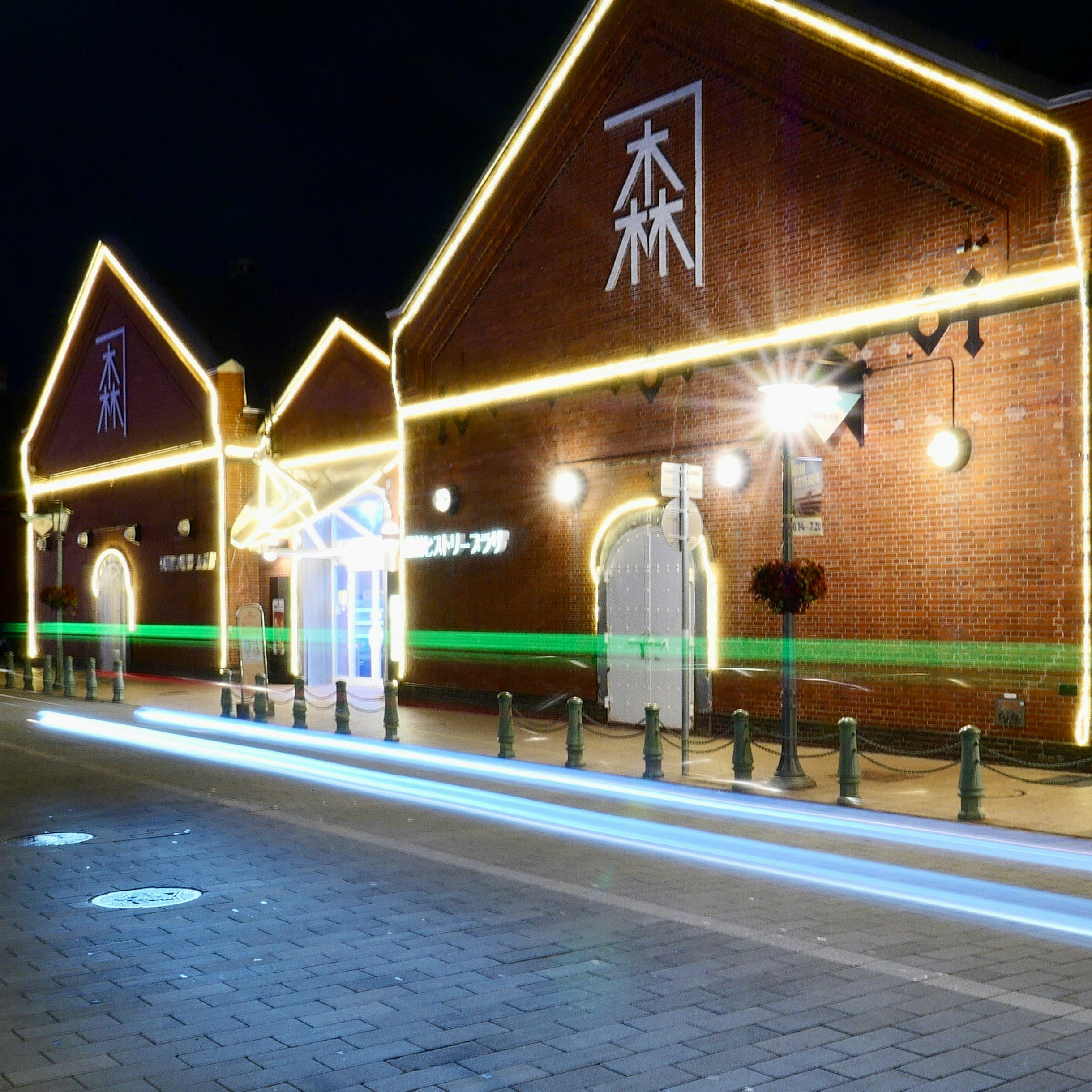 北海道・函館の金森赤レンガ倉庫をライトアップする夏の夜の光跡