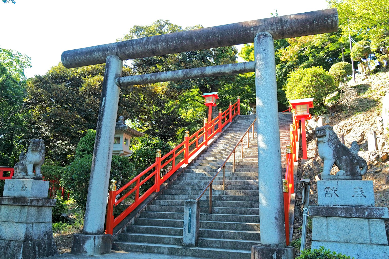 Aussicht auf einen Schrein mit einem roten Torii und Treppen