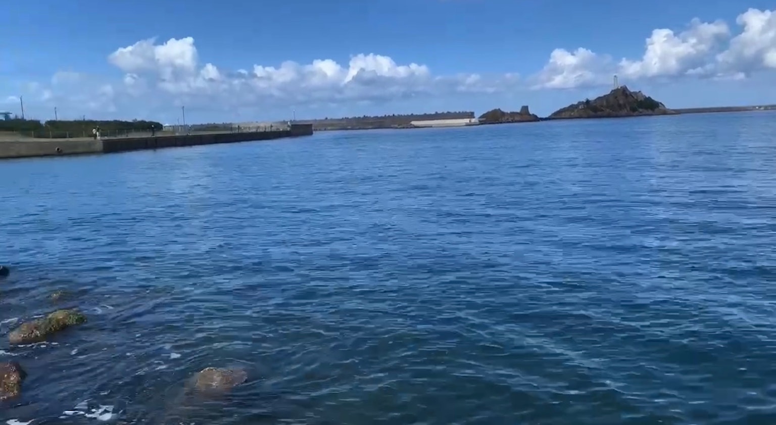 Scène marine tranquille avec ciel bleu et île au loin