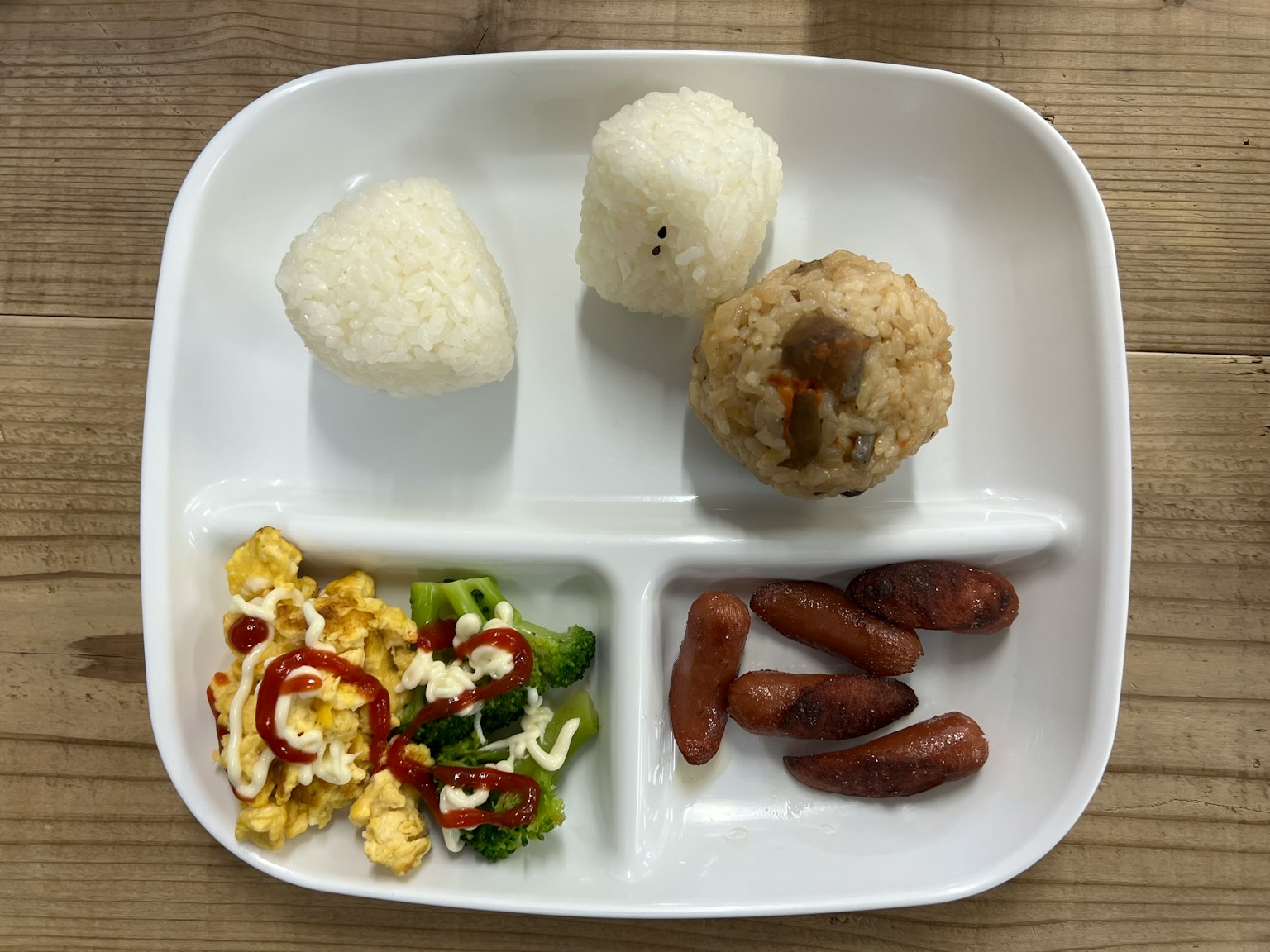 Un plato con bolas de arroz y guarniciones variadas