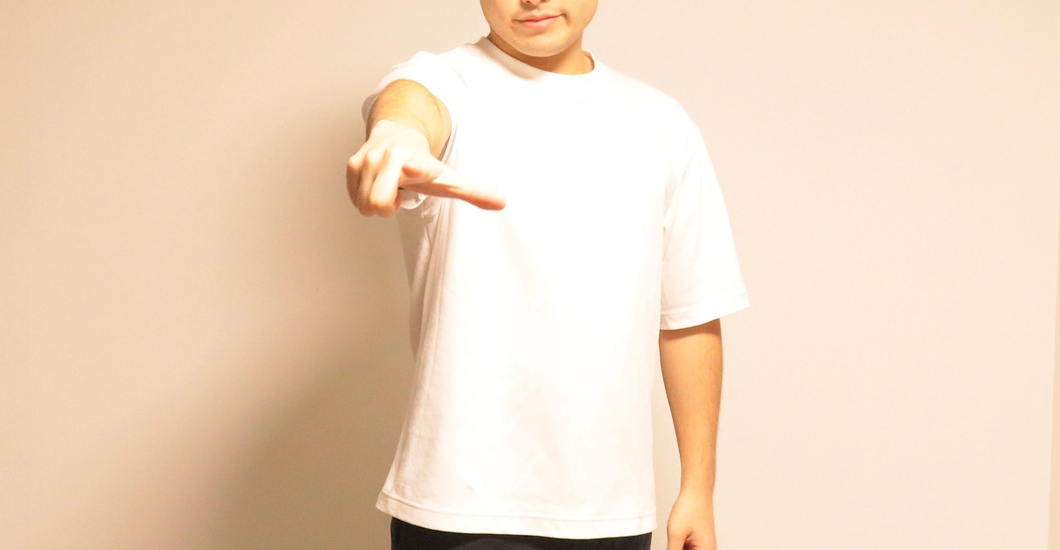 Un homme en t-shirt blanc pointant avec sa main