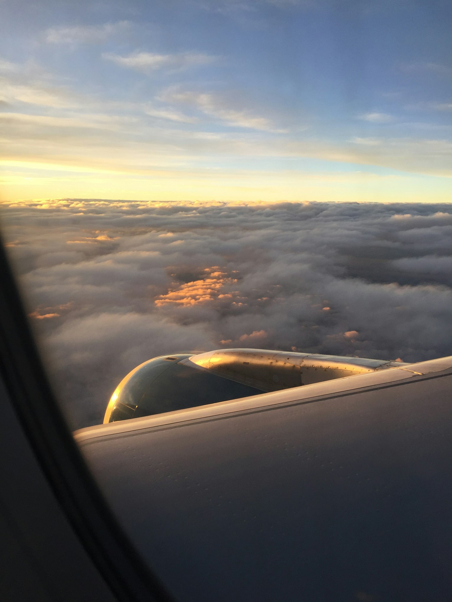 Schöne Aussicht auf Wolken und Sonnenuntergang aus einem Flugzeugfenster