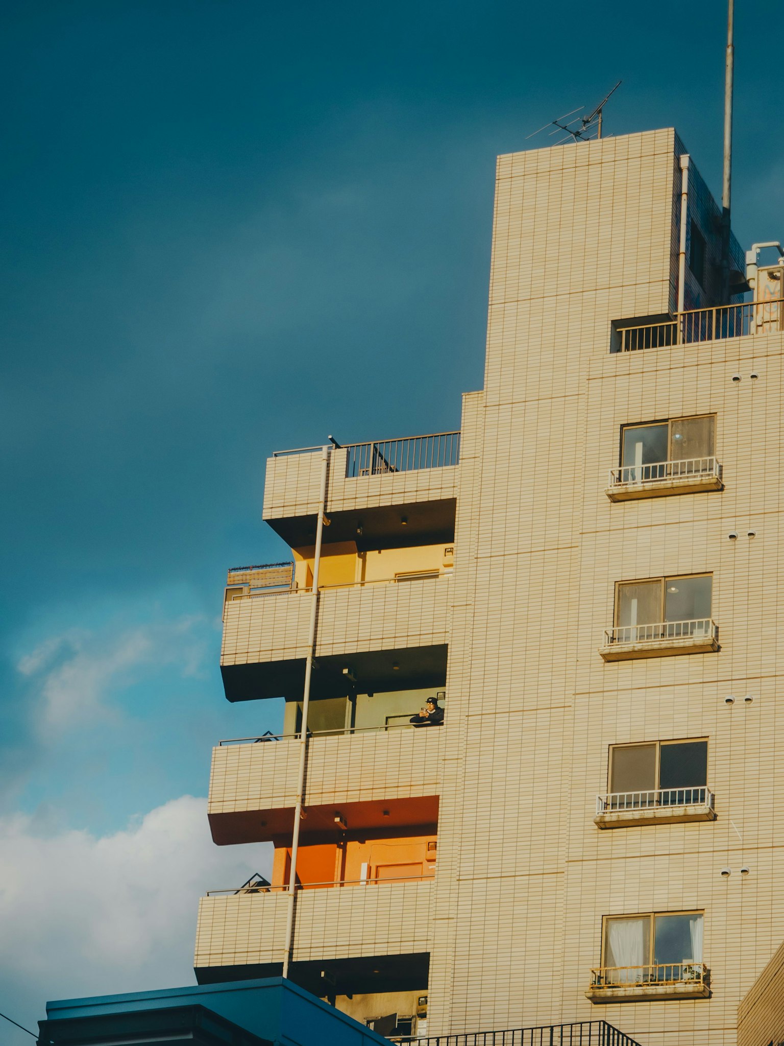 Immeuble moderne sous un ciel bleu avec des balcons colorés