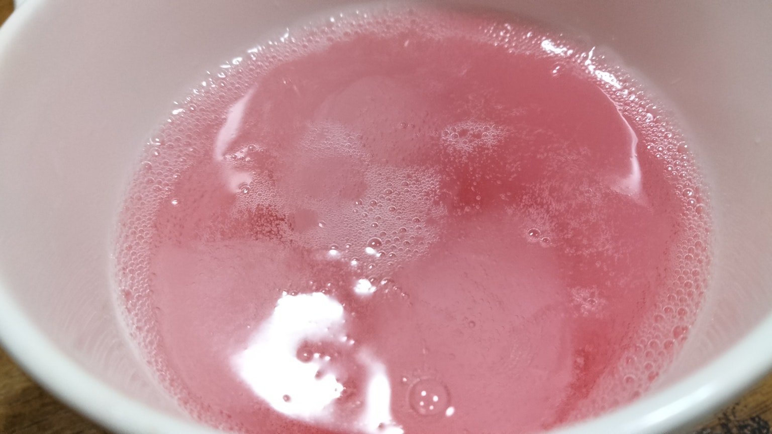 Schaumige rosa Flüssigkeit in einer weißen Schüssel