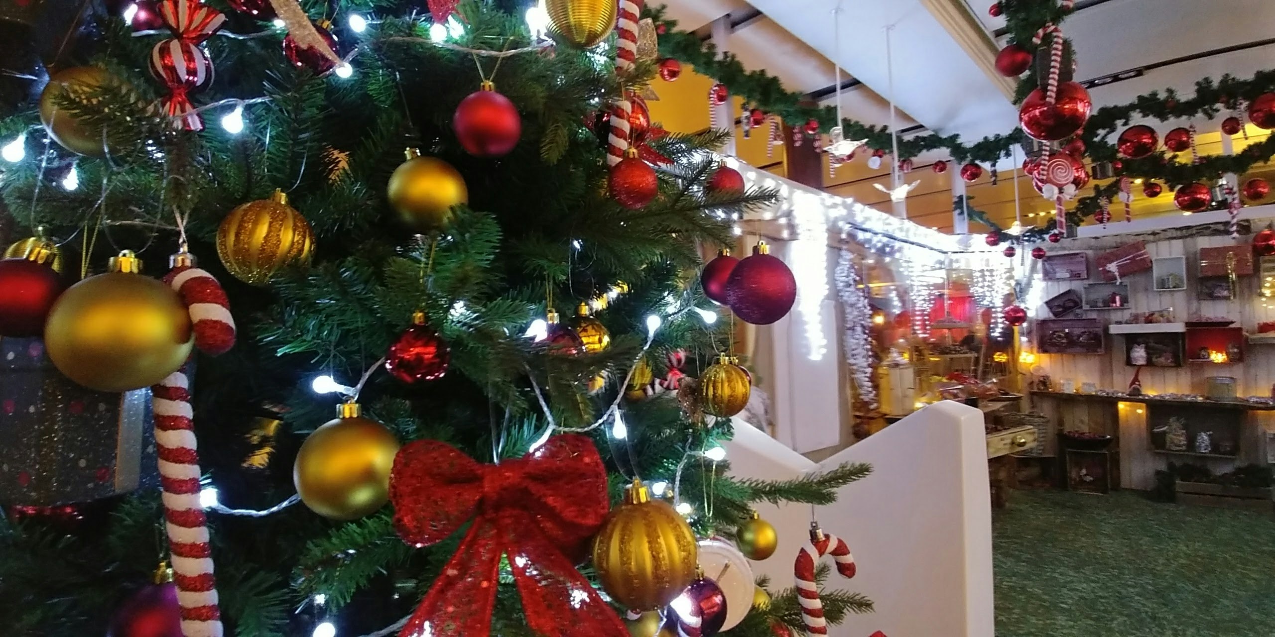 クリスマスツリーと飾り付けの店内のにぎやかな通路