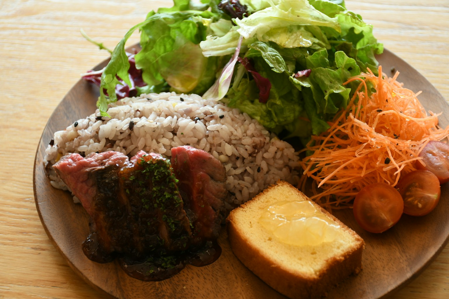 Ein Teller mit buntem Salat, Reis, Fleischgericht und Dessert