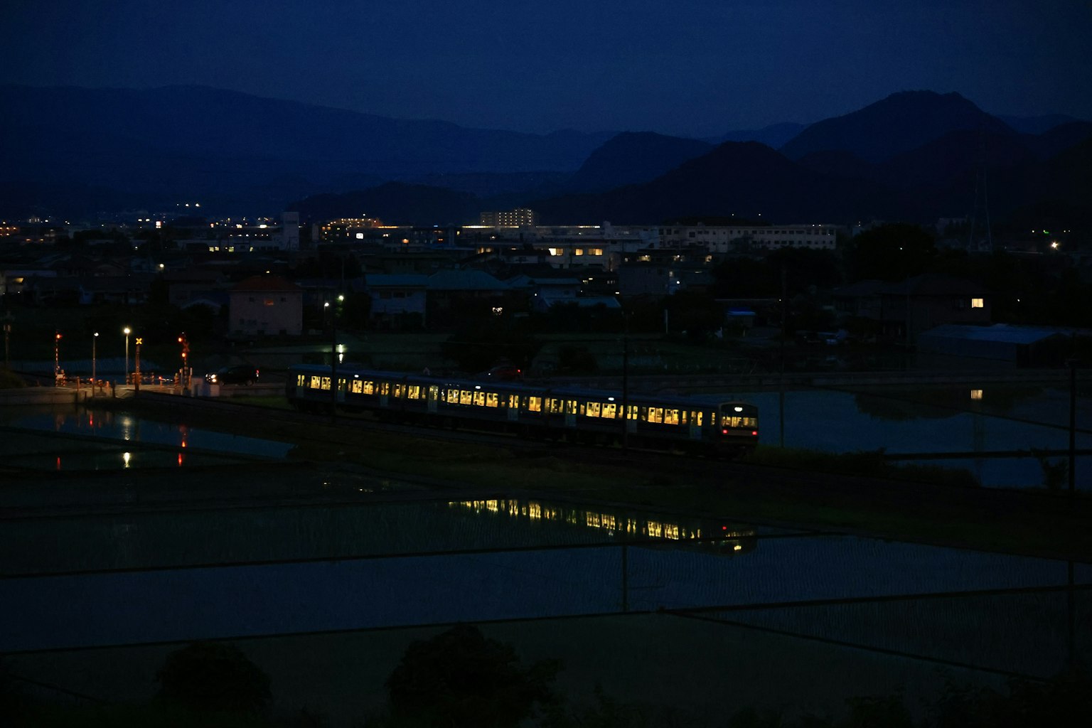 夜晚鄉村景觀中反射的火車燈光