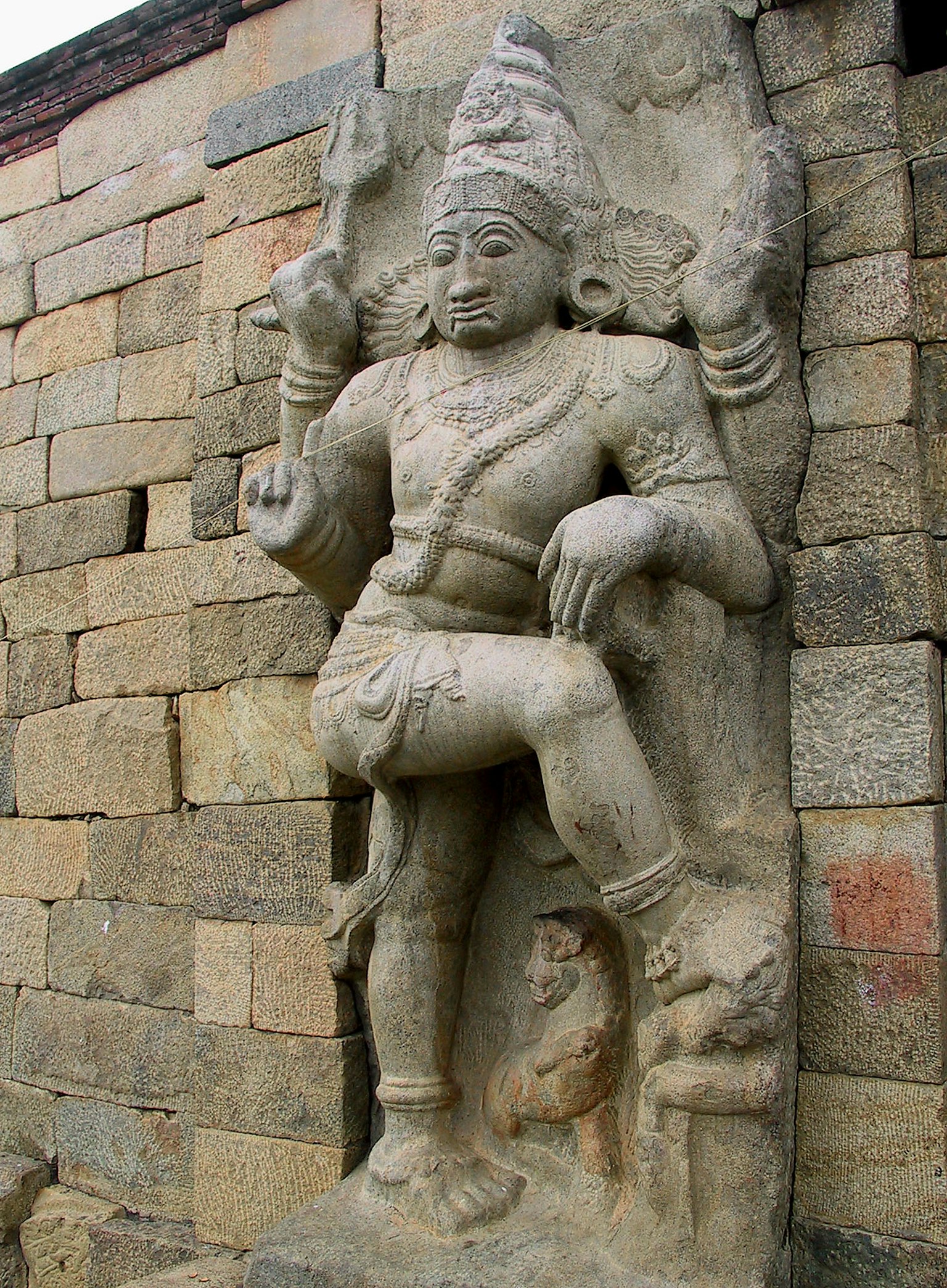 Stone sculpture of a deity carved into a wall