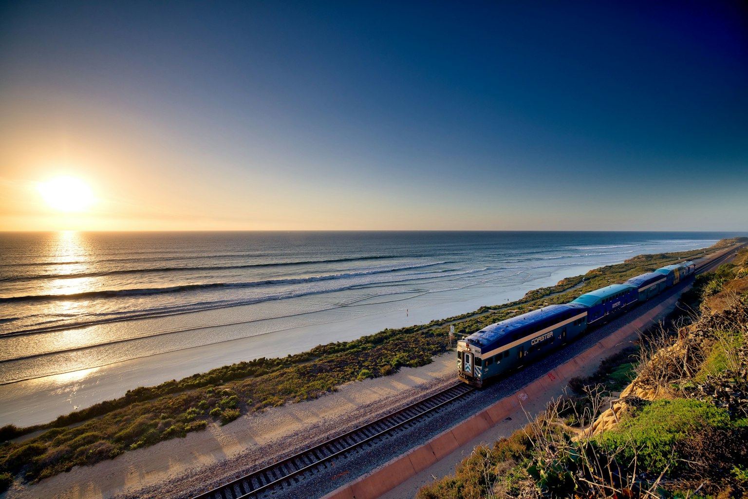 Vista panoramica di un treno lungo la costa al tramonto