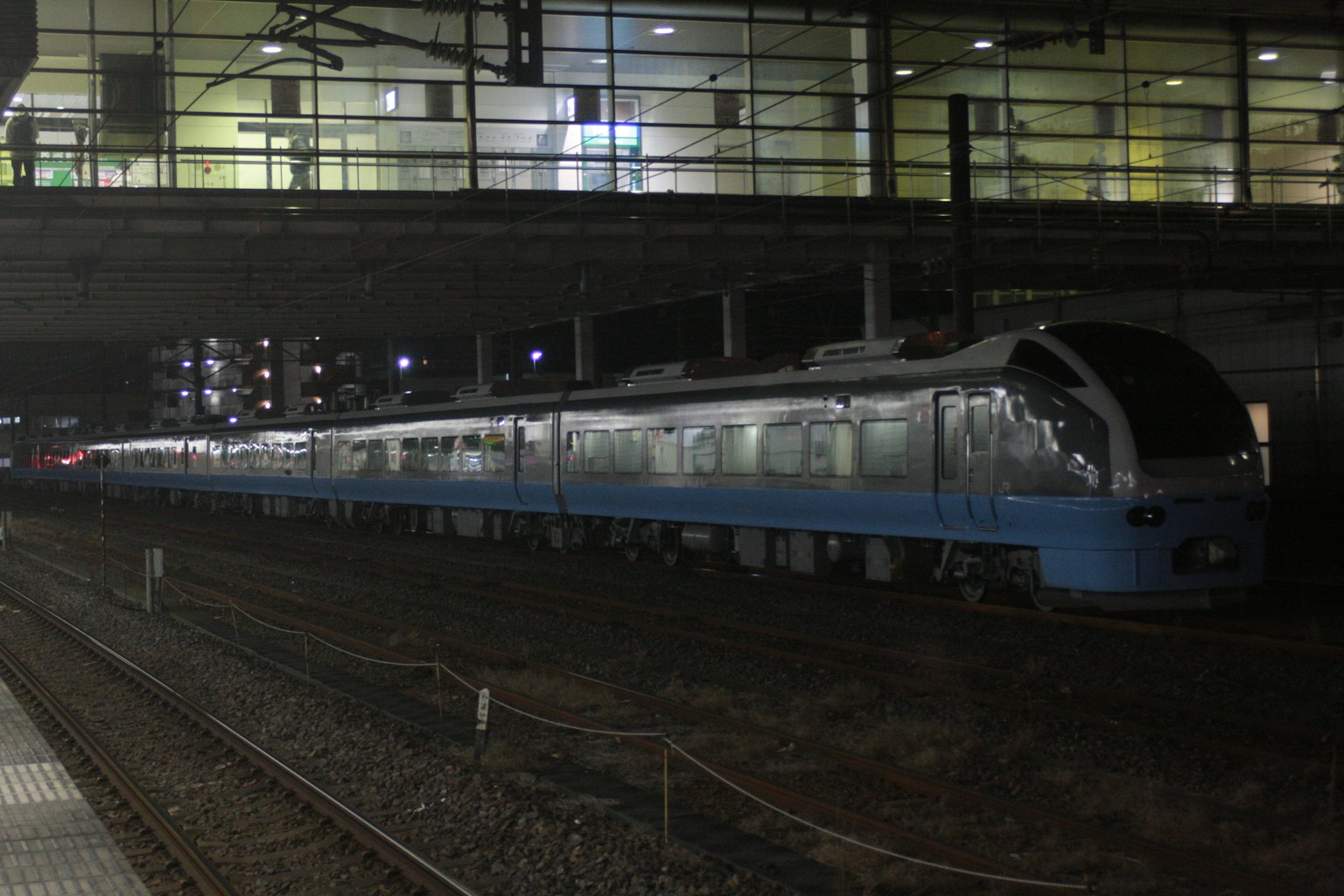 รถไฟสีน้ำเงินจอดอยู่ที่สถานีในเวลากลางคืน
