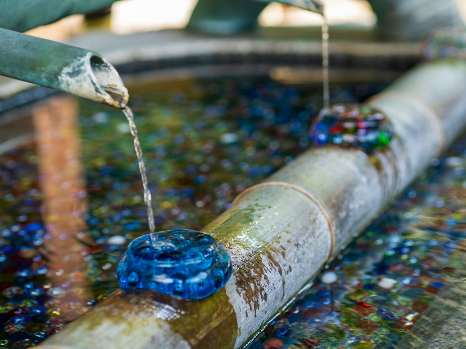 Fontana in bambù con acqua che scorre e decorazioni in vetro blu