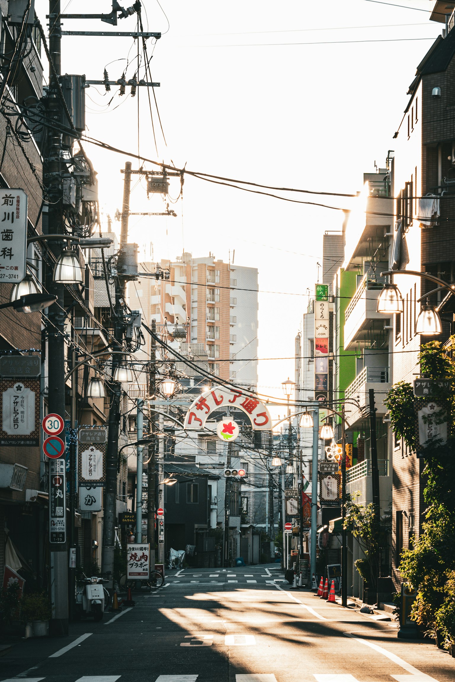 Escena de calle japonesa tranquila con líneas eléctricas cruzadas edificios y carteles comerciales