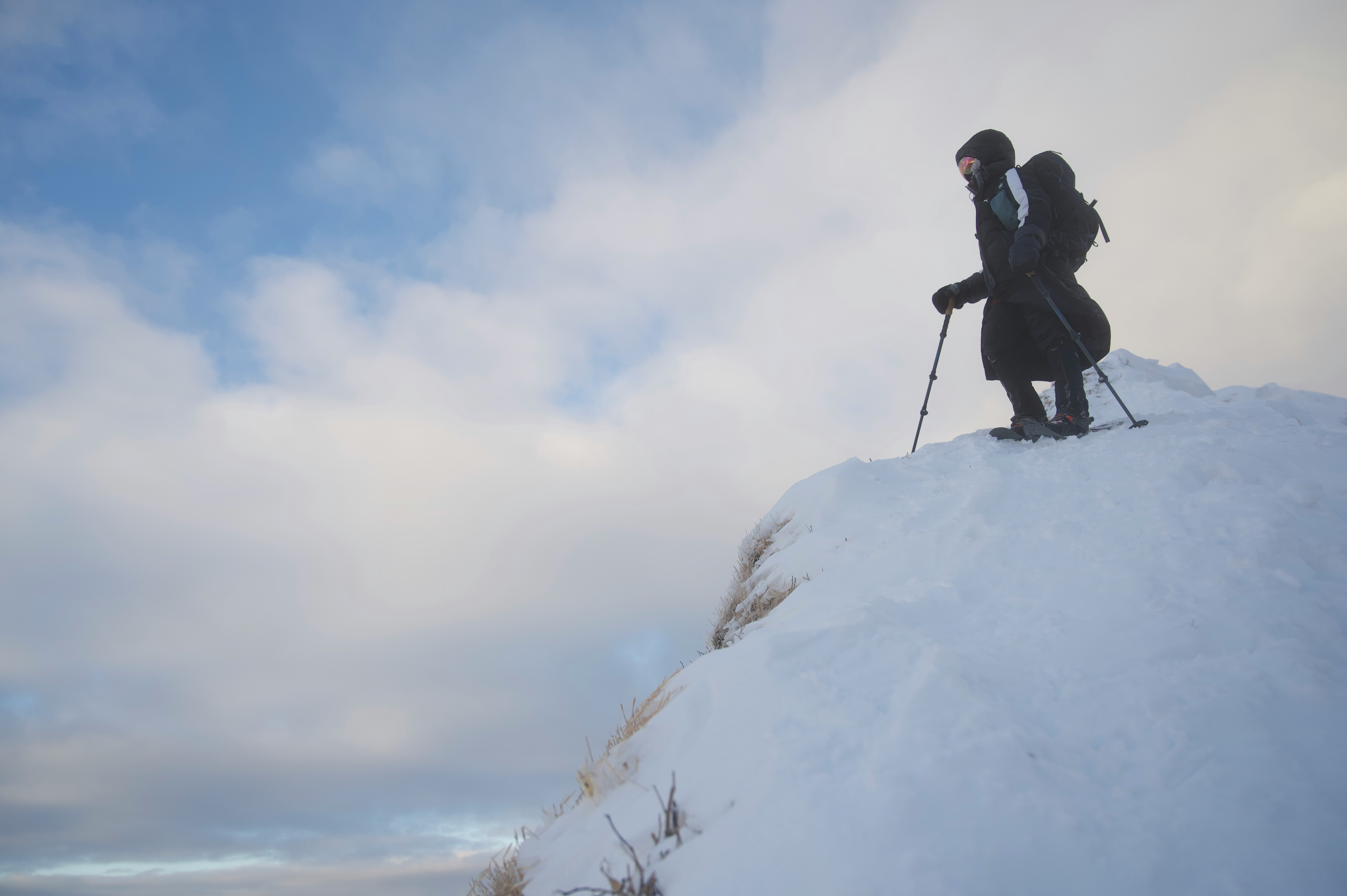 雪の山頂でスキーを楽しむ登山者のシルエット