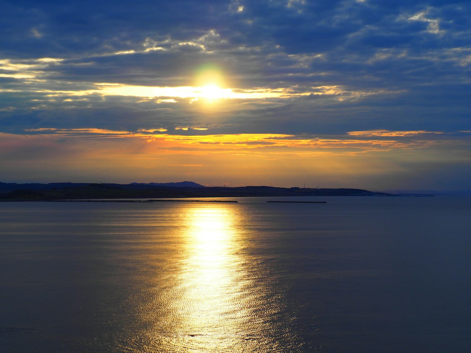 Bellissimo tramonto sull'oceano con cielo blu luce dorata e superficie d'acqua calma