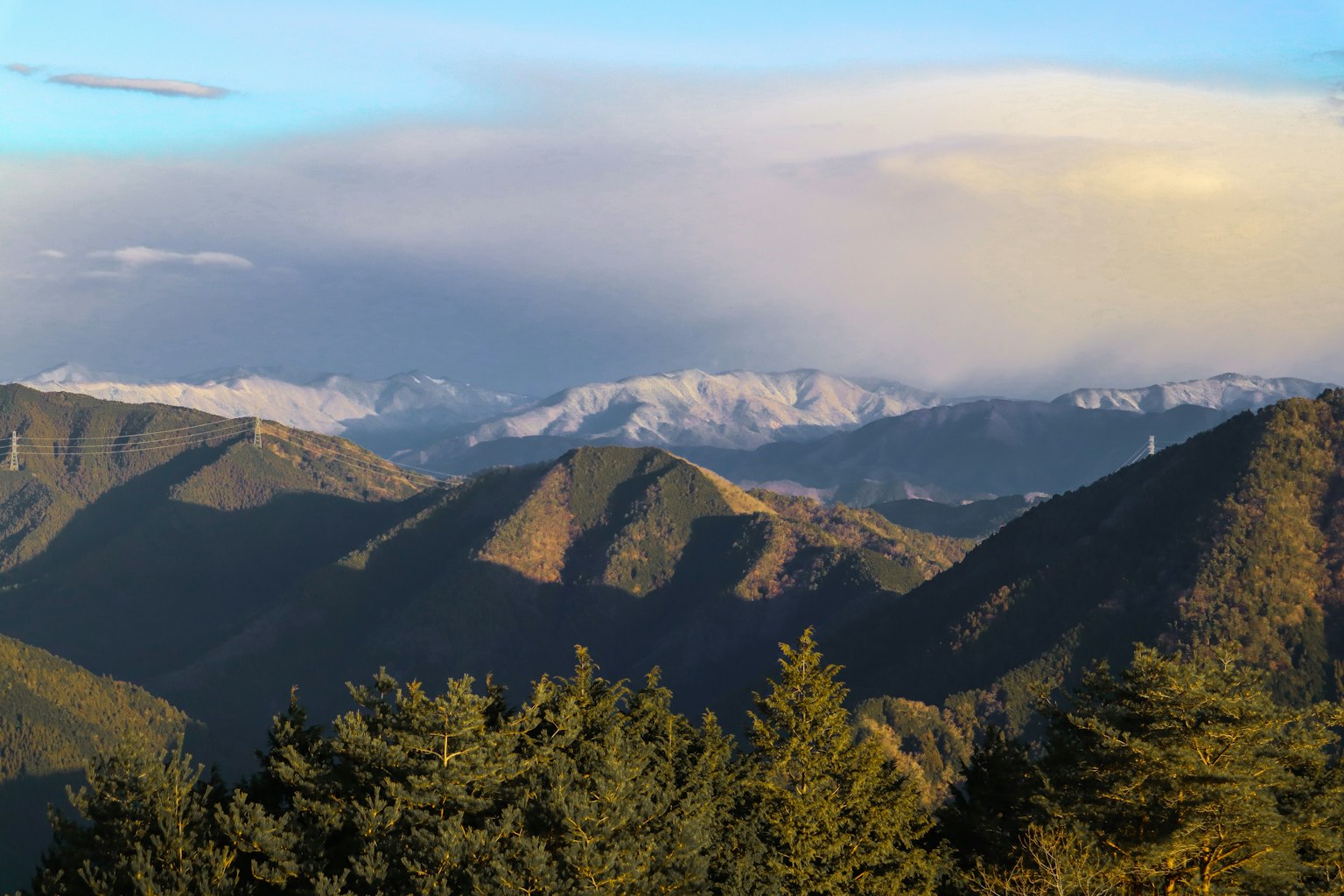 Vista panoramica di montagne e foresta sotto un cielo blu