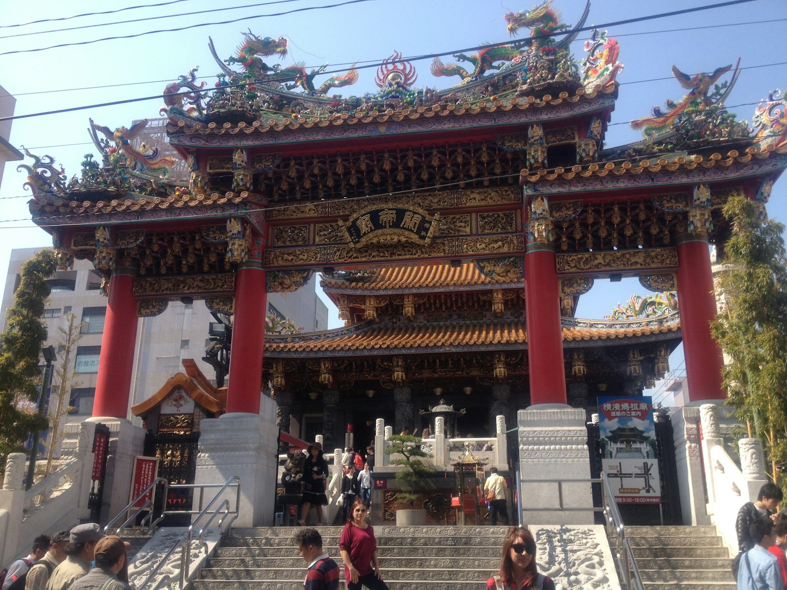 Entrée d'un temple chinois avec un toit coloré et des décorations complexes de nombreux visiteurs