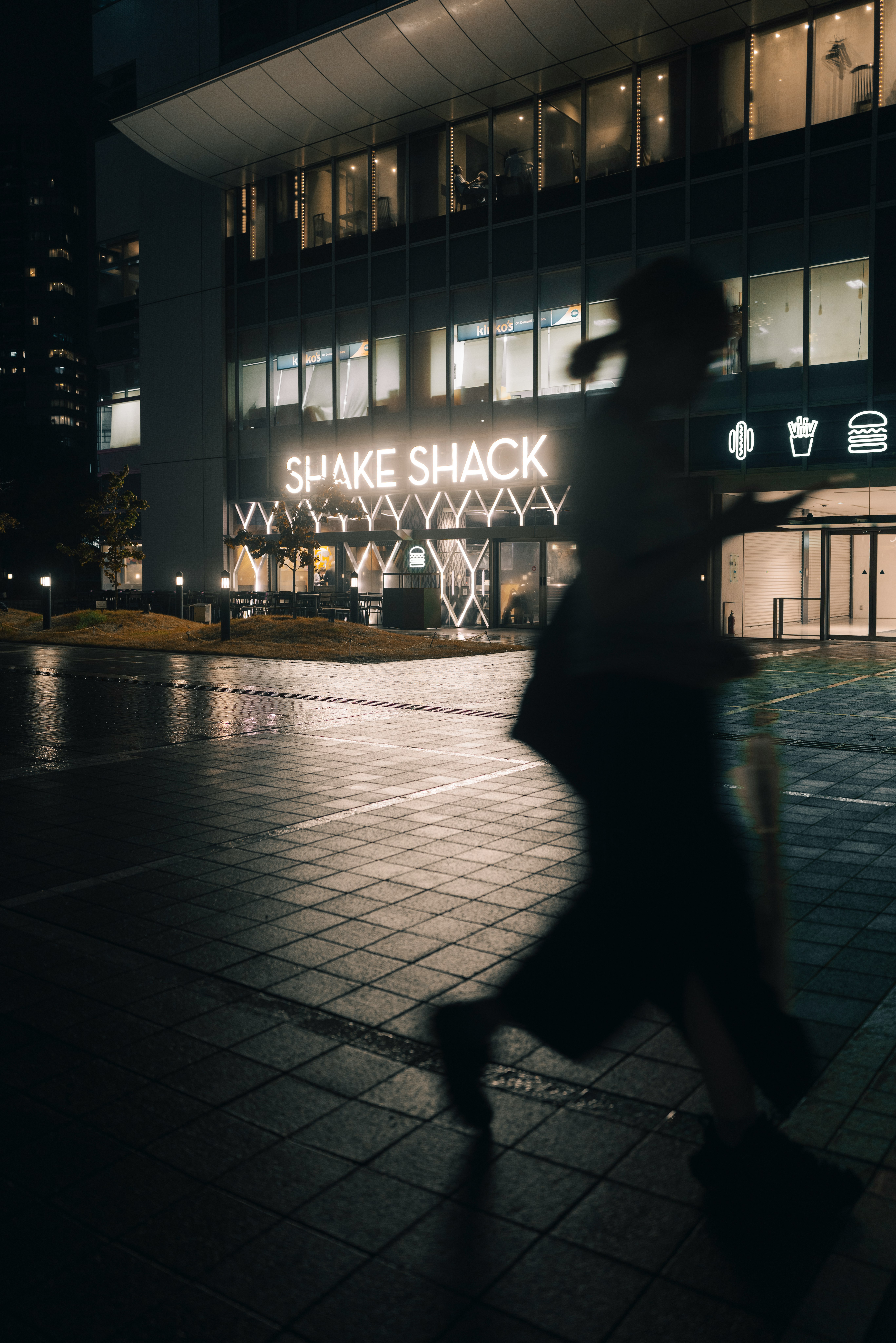 夜の屋外で「SHAKE SHACK」の看板が光る店舗前
