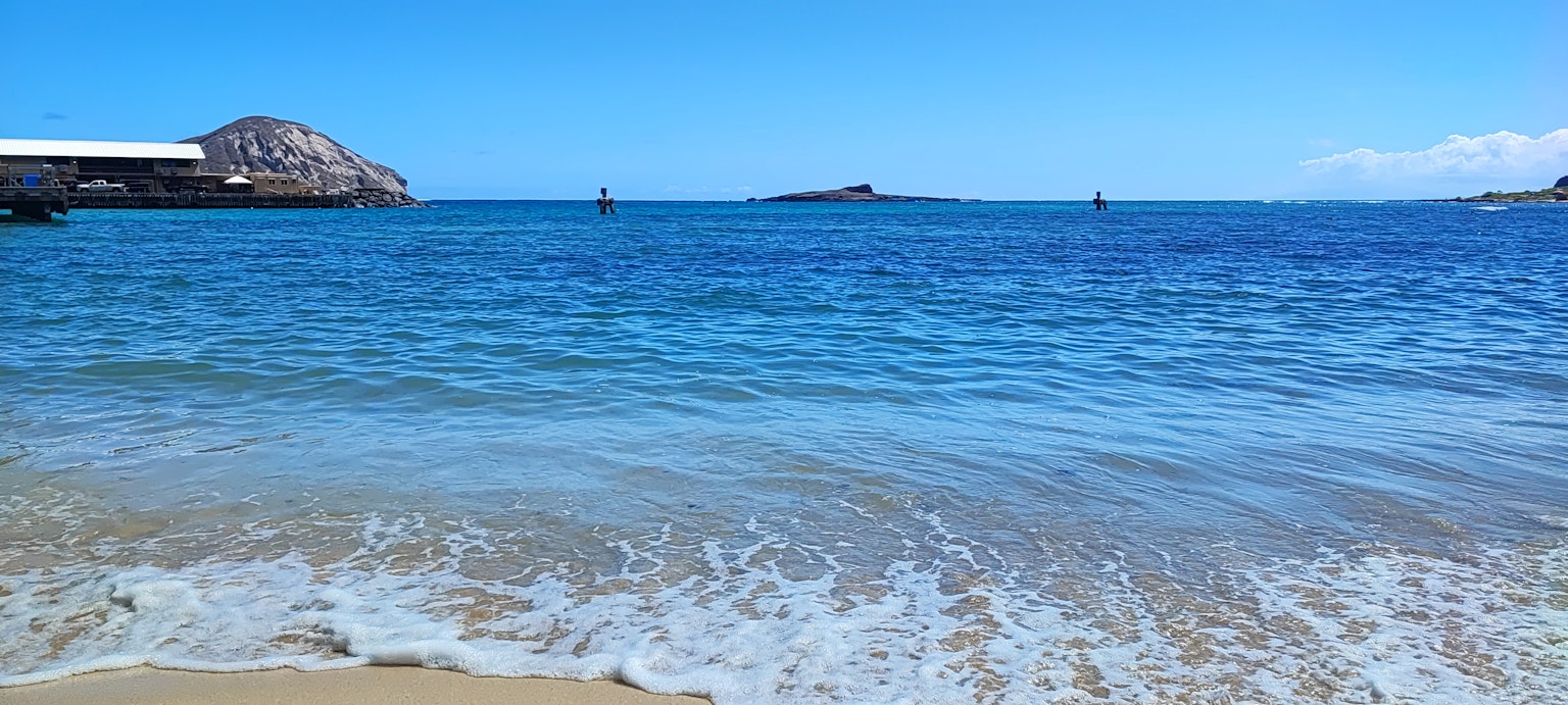 藍色海洋的風景，沙灘和遠處的船隻