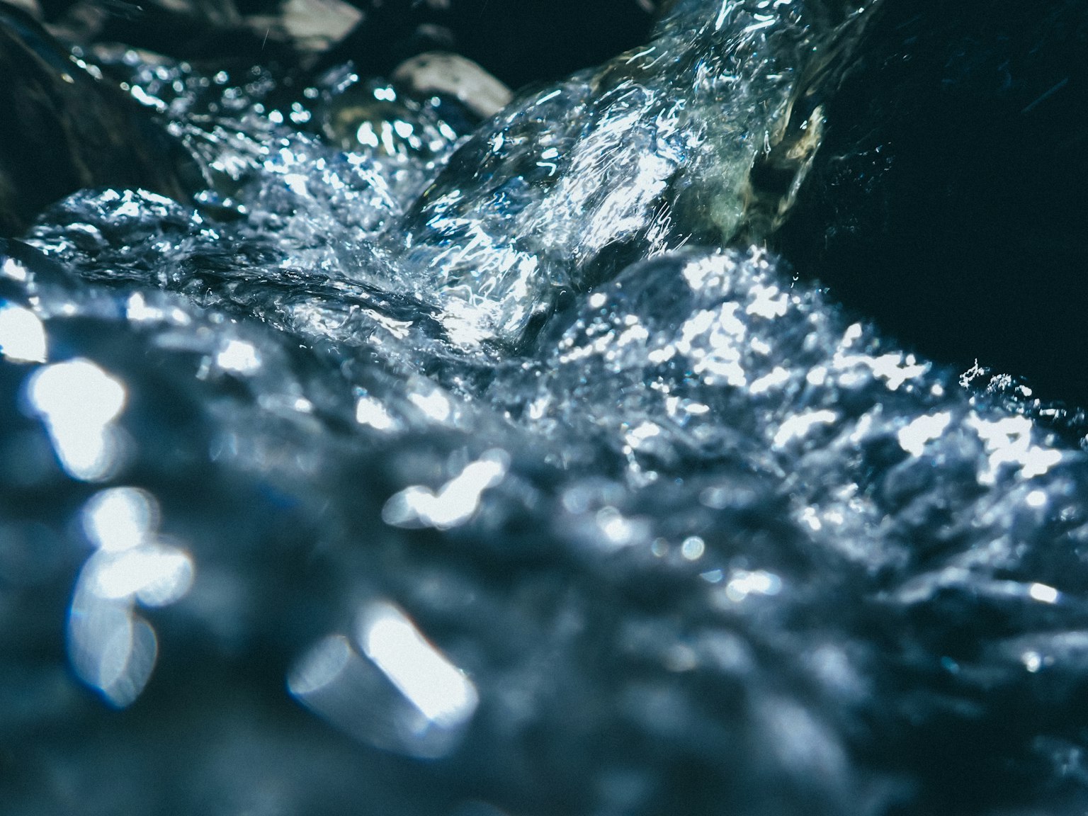 Immagine ravvicinata di acqua che scorre con belle riflessioni di luce