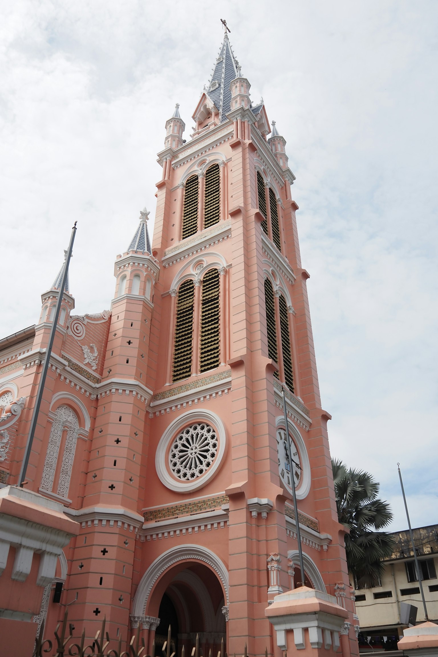 Tour d'église haute avec façade rose et architecture détaillée