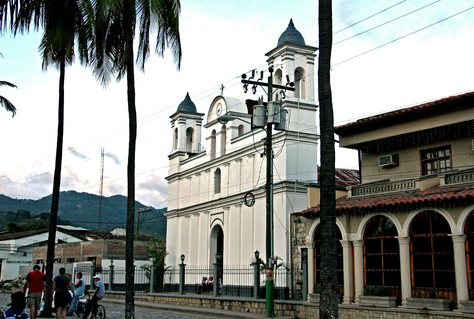 Vista di strada con una chiesa bianca e montagne sullo sfondo